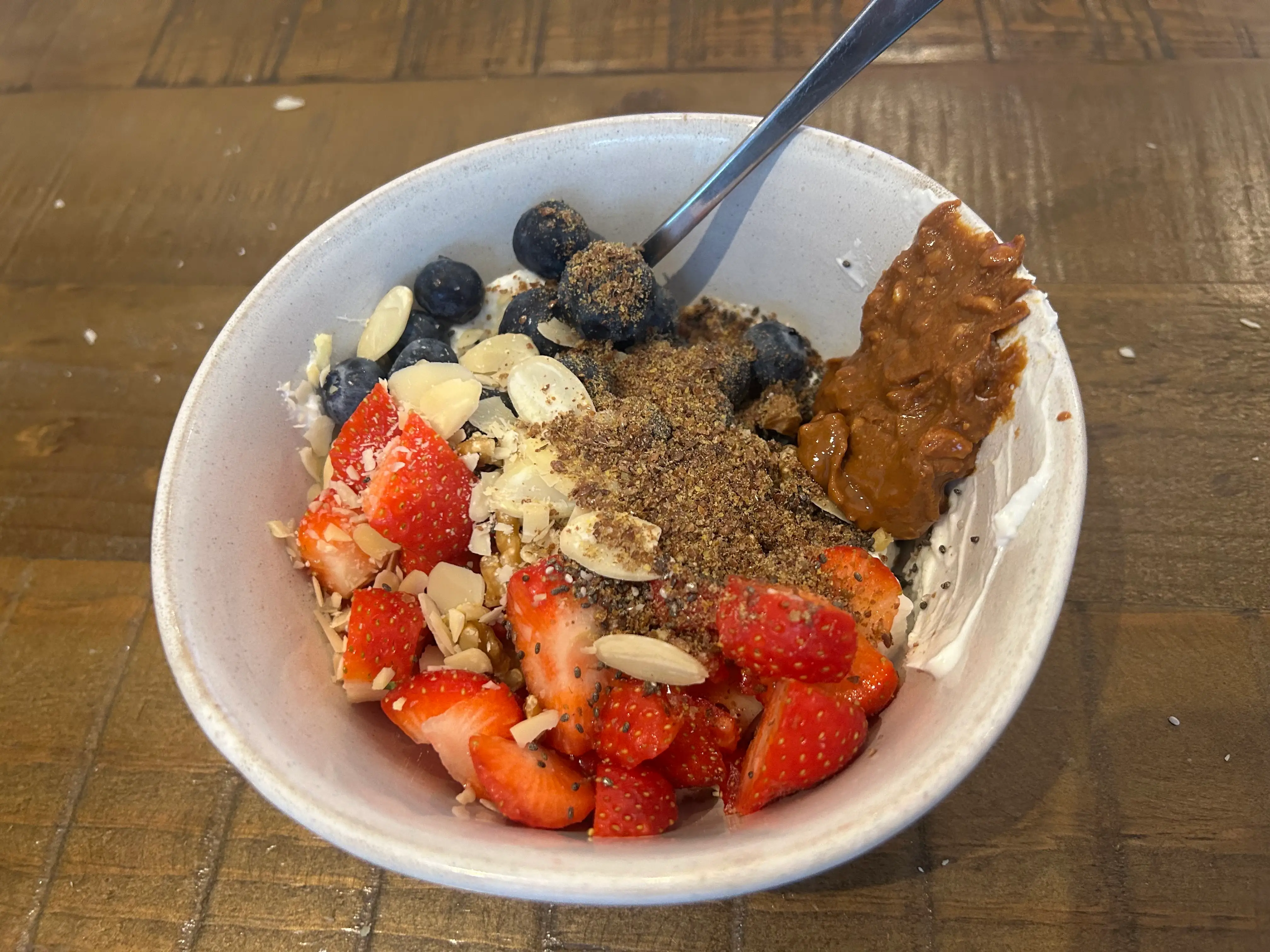 A yogurt bowl with peanut butter and berries.