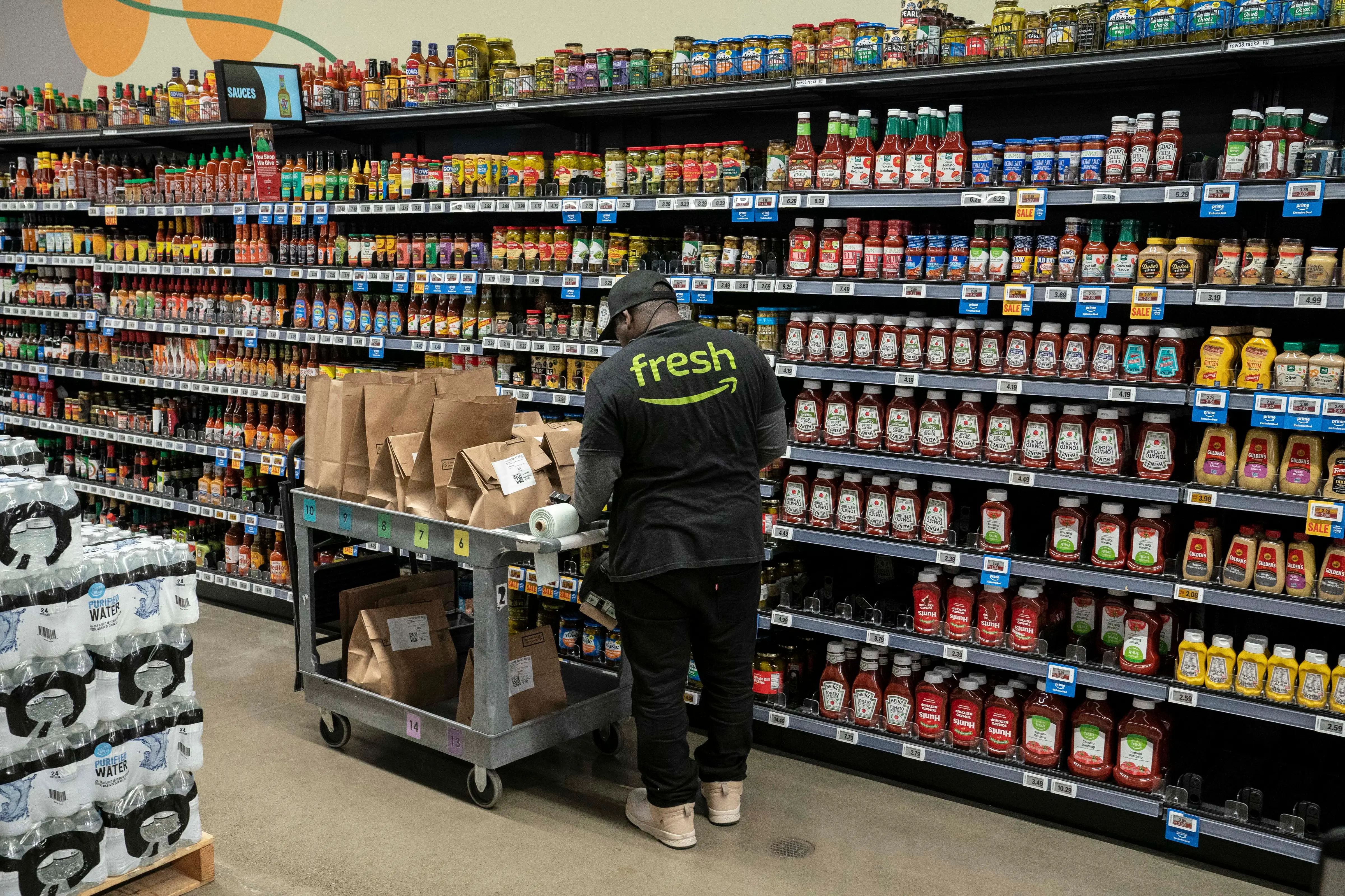 An employee picks orders for customers at an Amazon Fresh grocery store on December 12, 2024 in Federal Way, Washington.