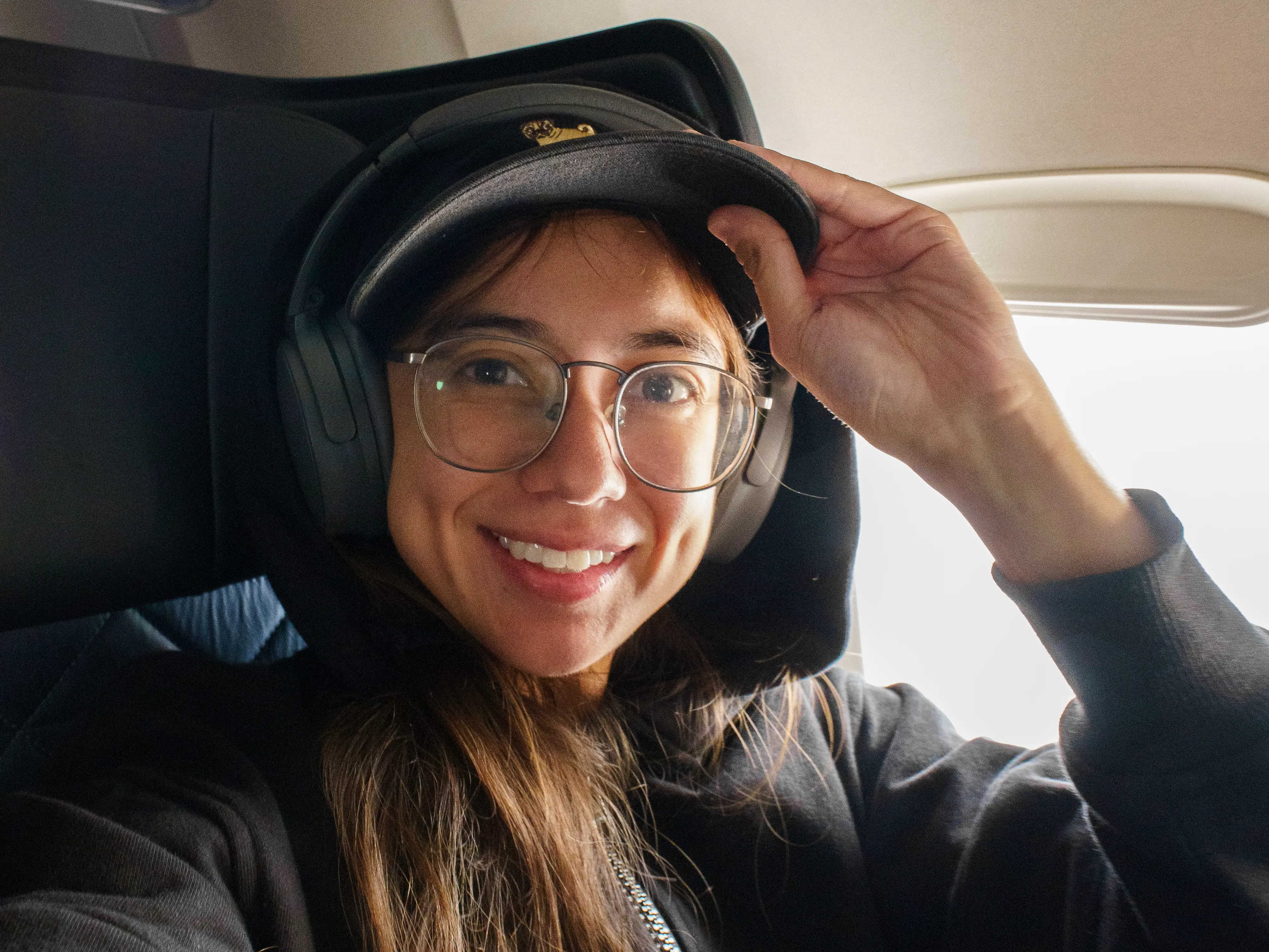The author sits smiling in a first-class window seat on a Delta flight