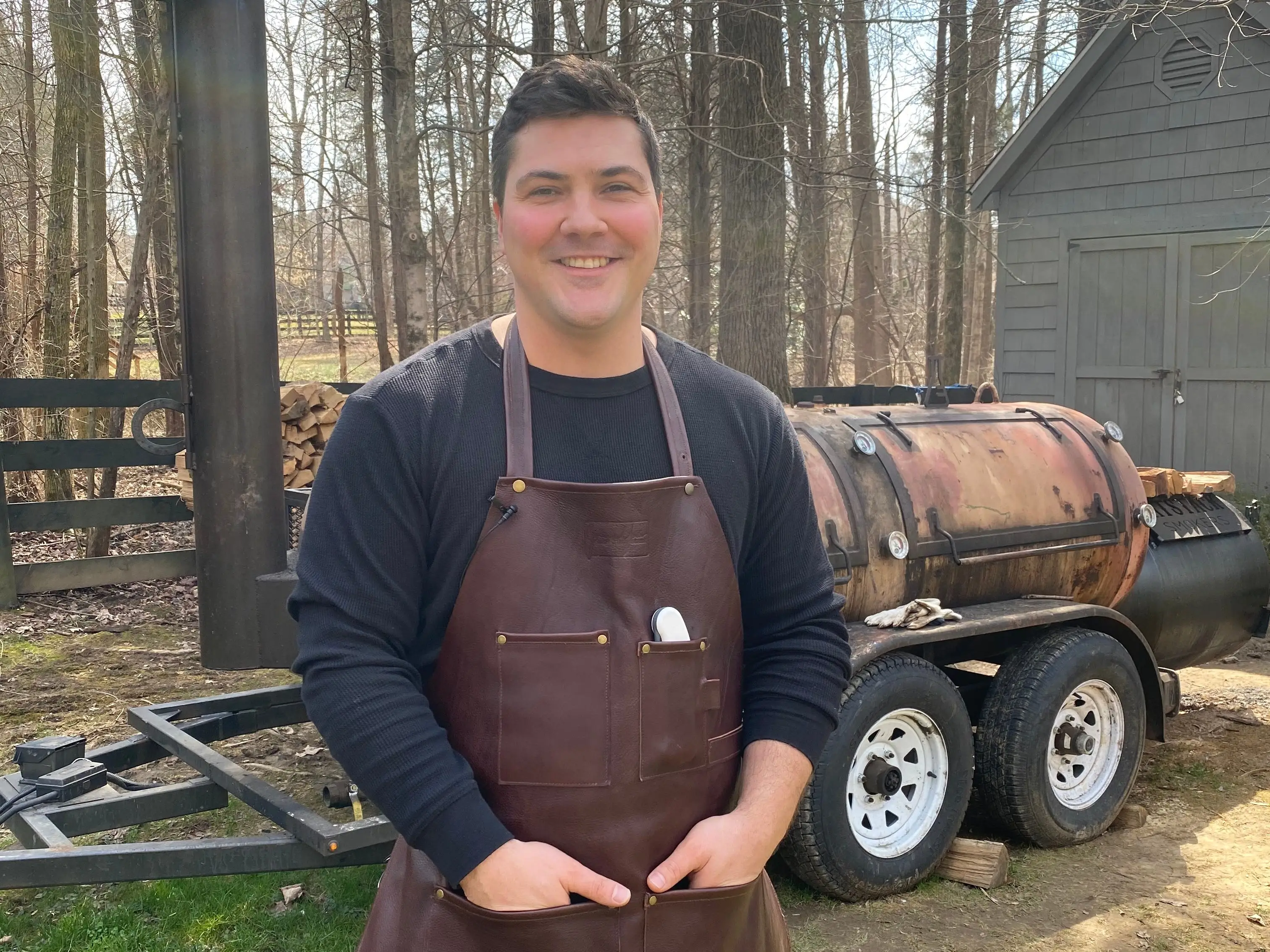 Jeremy Yoder, host of Mad Scientist BBQ, poses in front of his smoker.