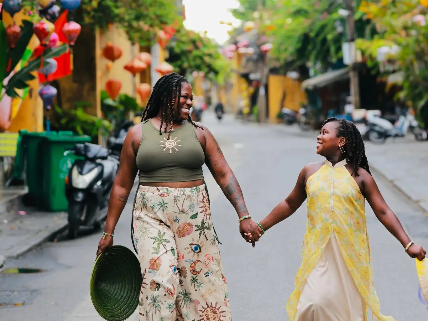 A woman holding hands with her daughter and walking down the street in Hoi An, Vietnam.