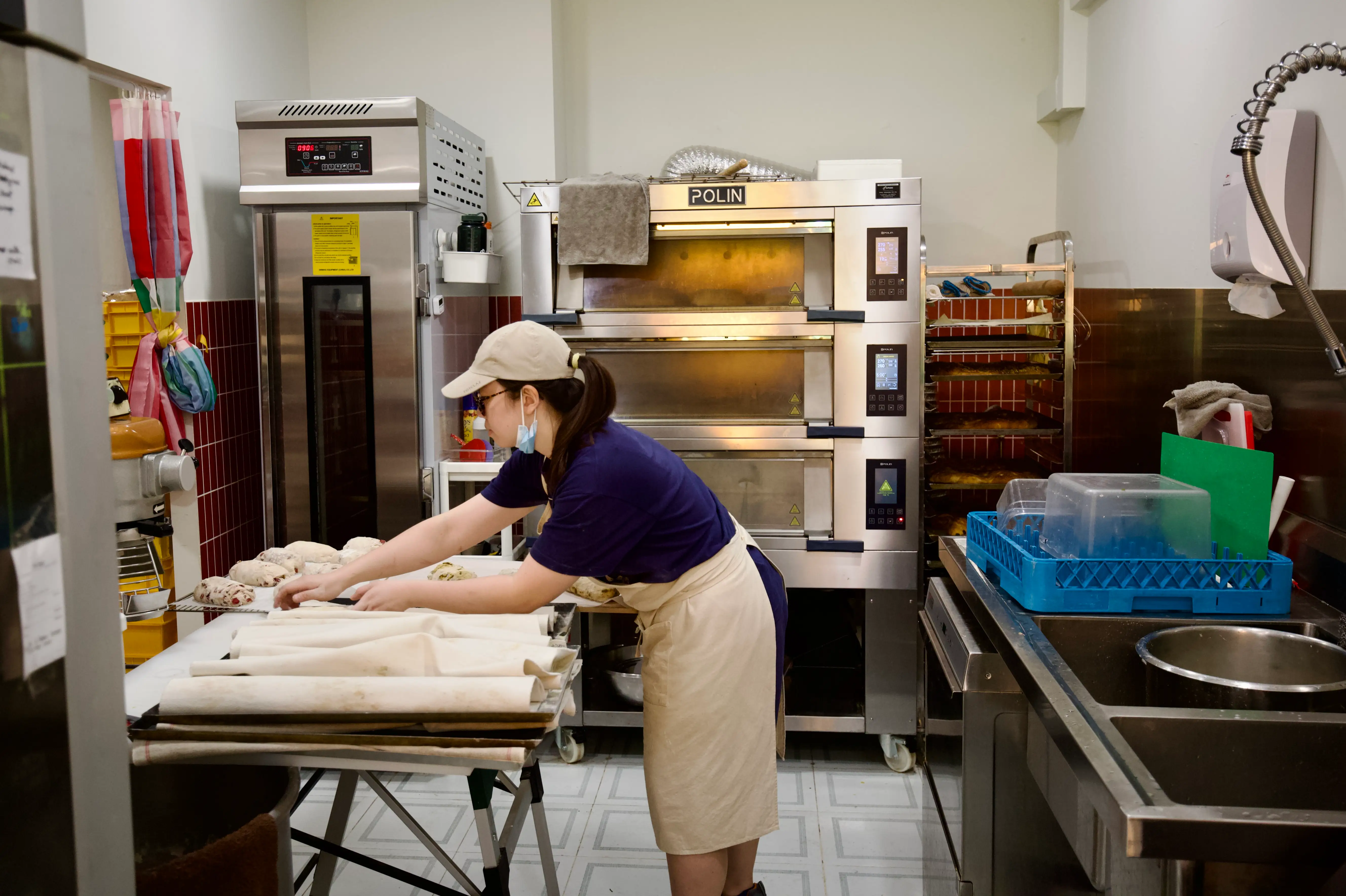 Au gets sourdough loaves ready for the oven.