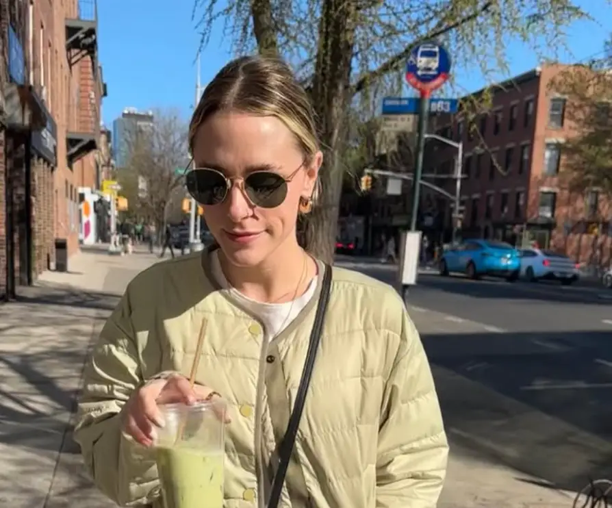 The writer strolling down the street in New York City with a matcha.