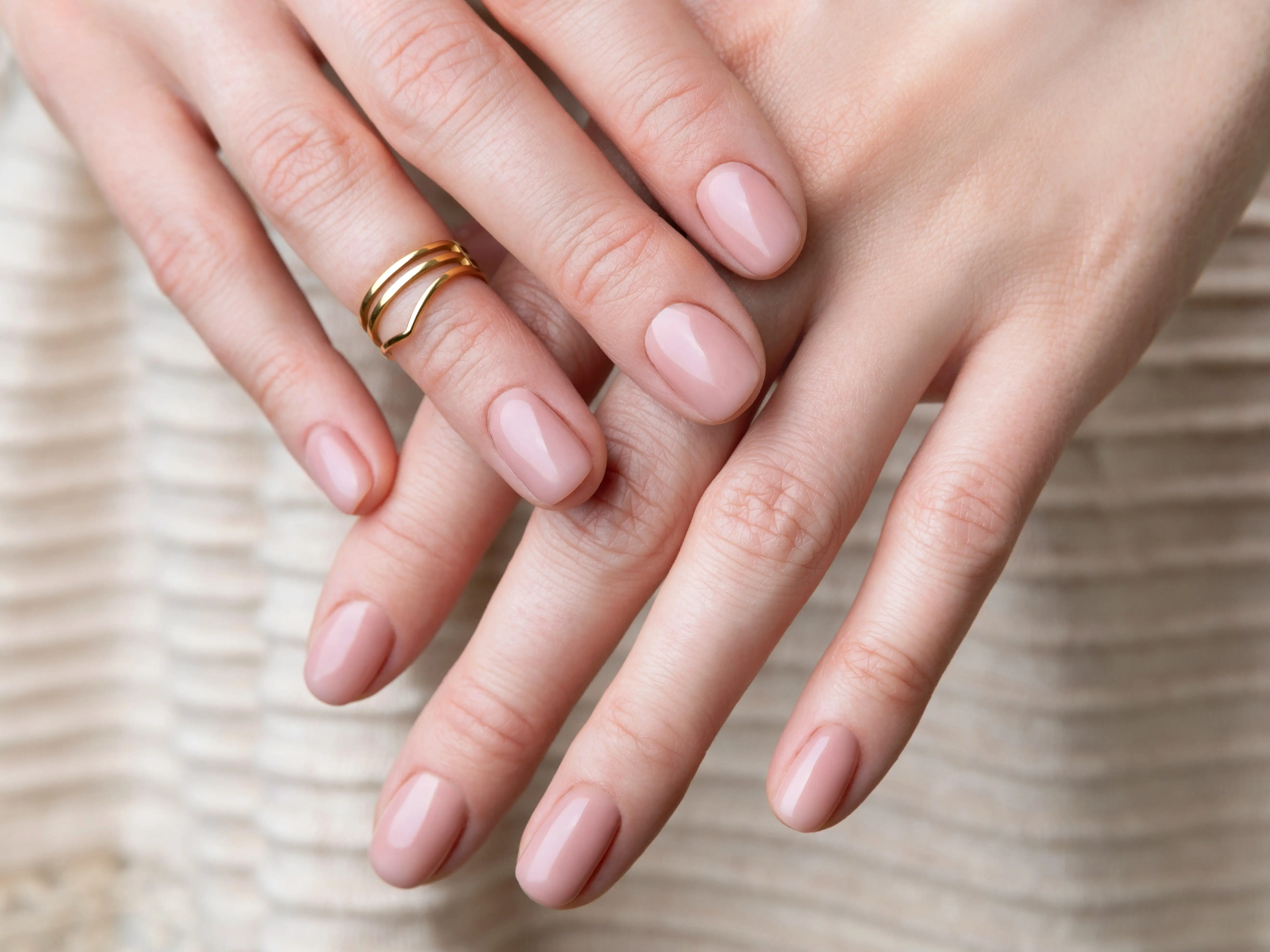 A pale-pink manicure with short, rounded nails.