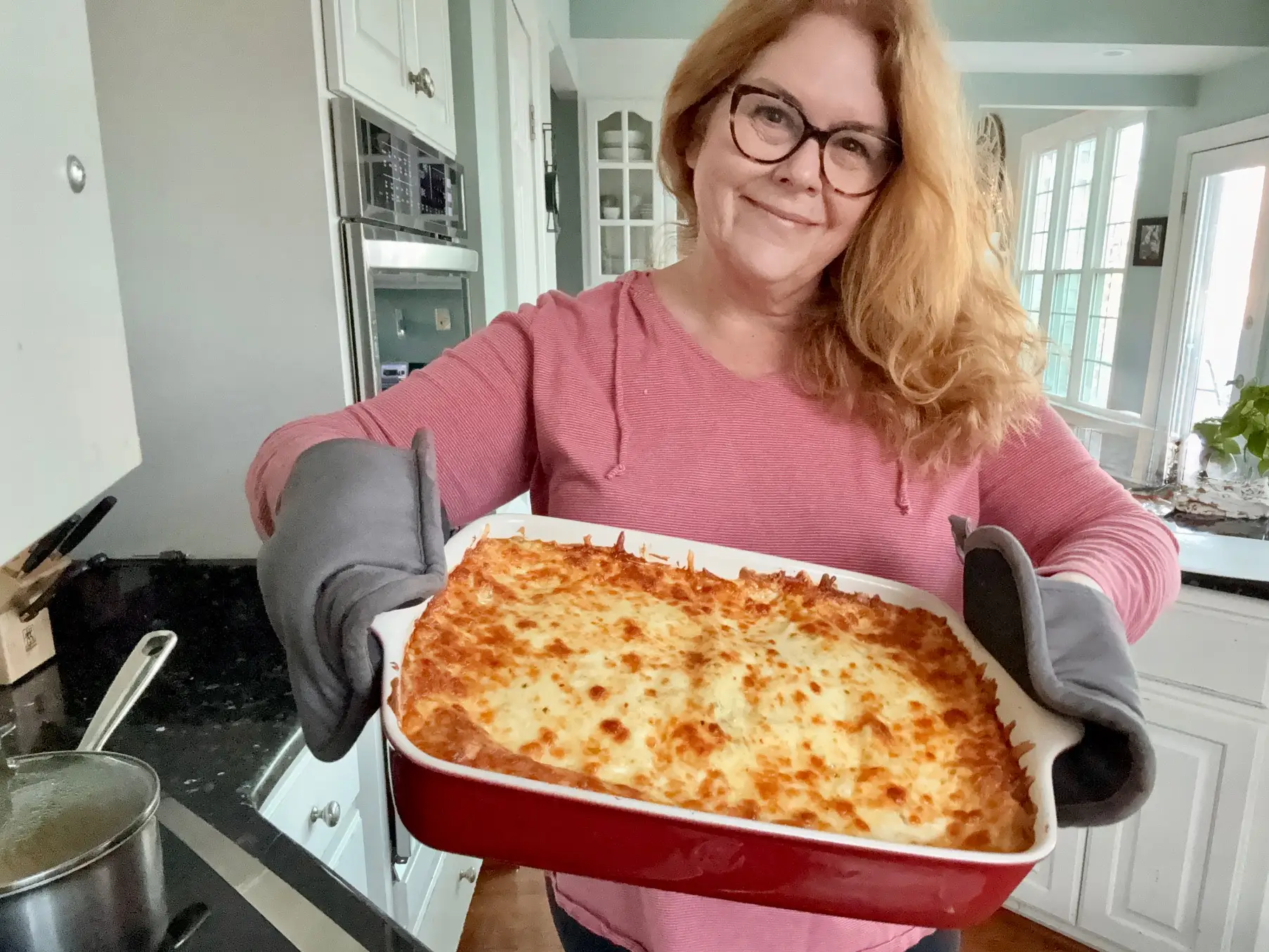 The author posing with the dish of completed enchiladas.