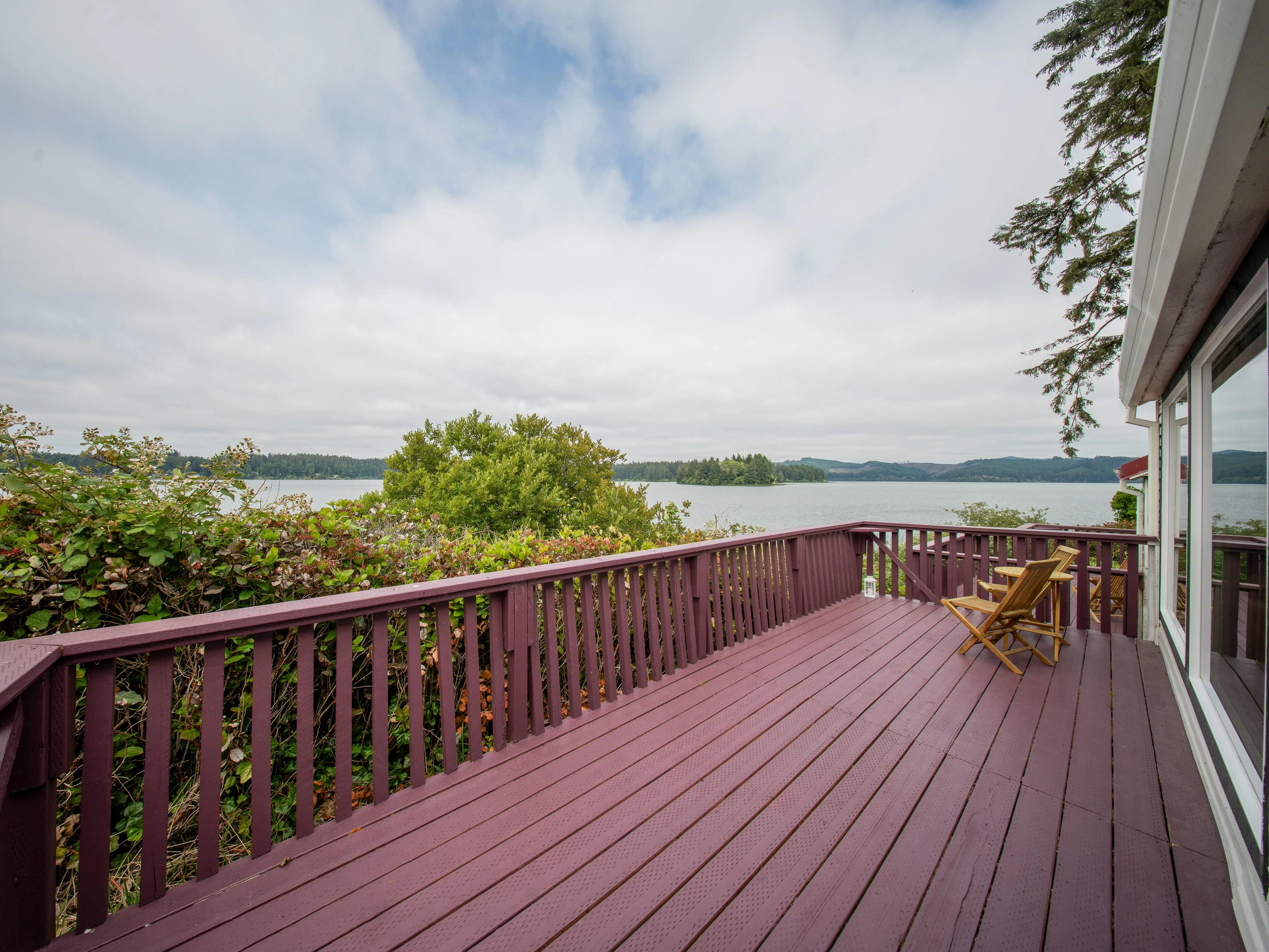 A red porch that overlooks water.