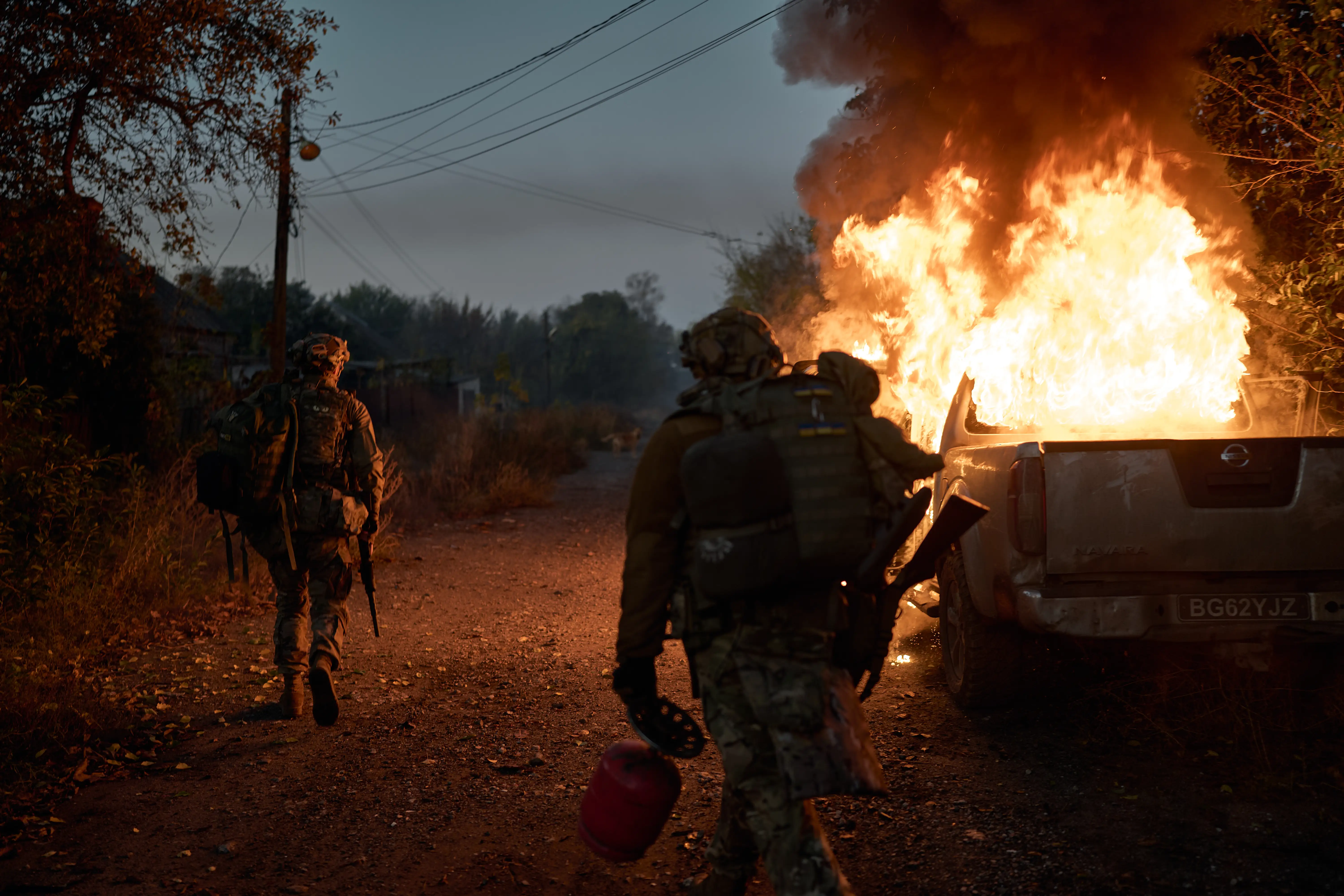 Ukrainian soldiers inspect a vehicle recently struck by a Russian FPV exploding drone that ambushed them near the frontline on October 16, 2025, in Kostiantynivka, Ukraine.