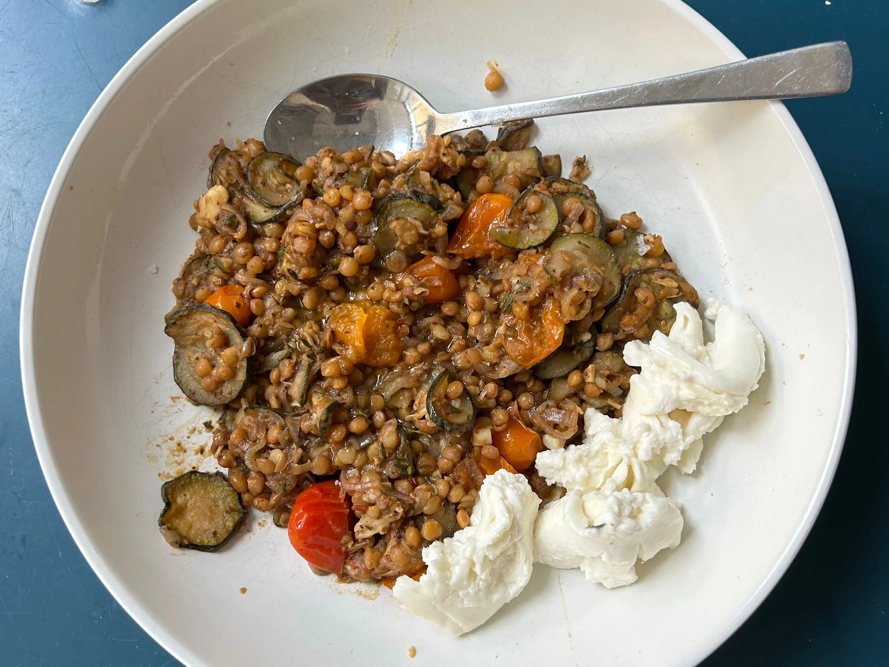 A bowl of lentil stew with mozzarella.
