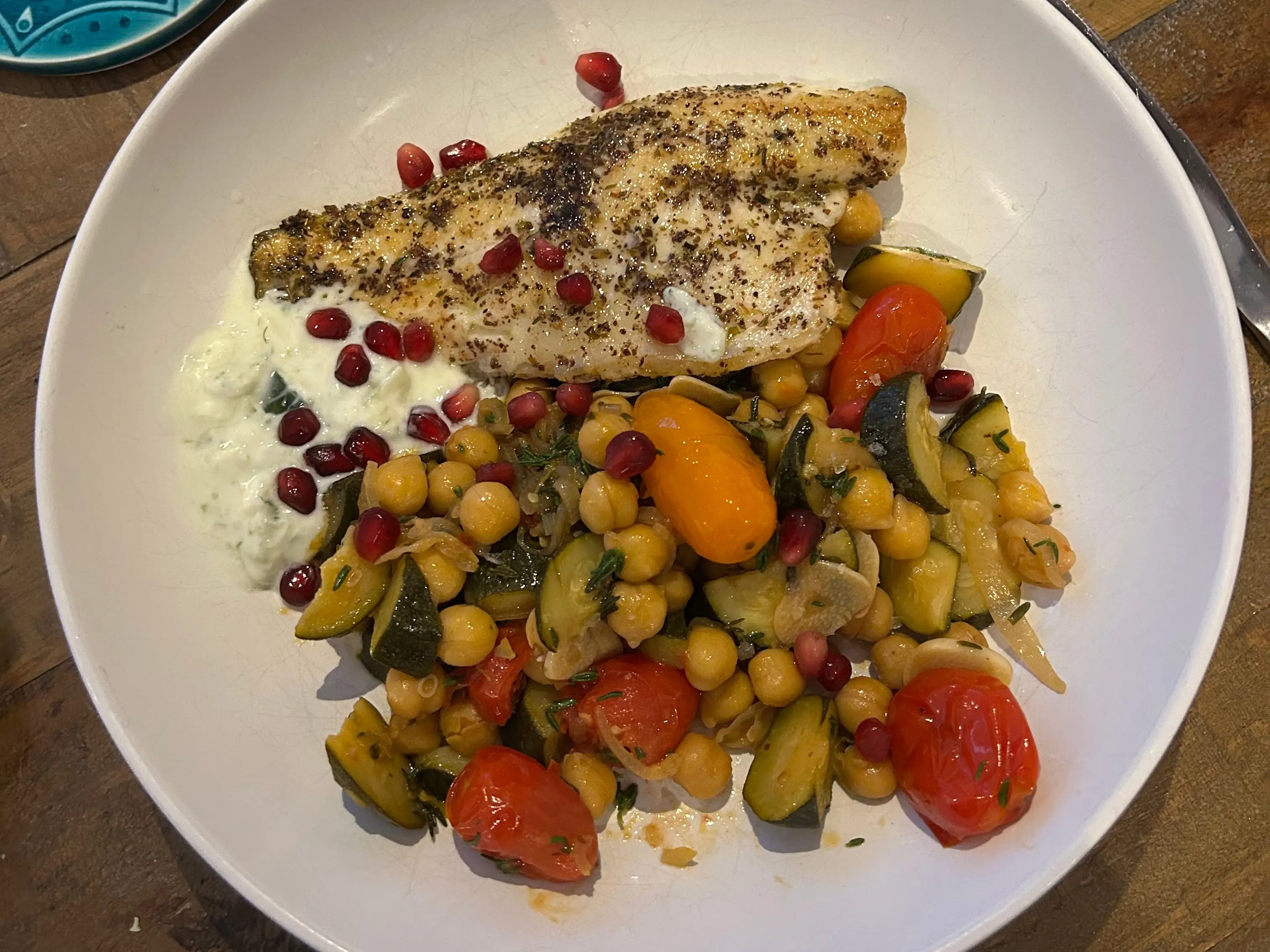 A bowl of grilled fish, chickpea stew, and garlic yogurt.