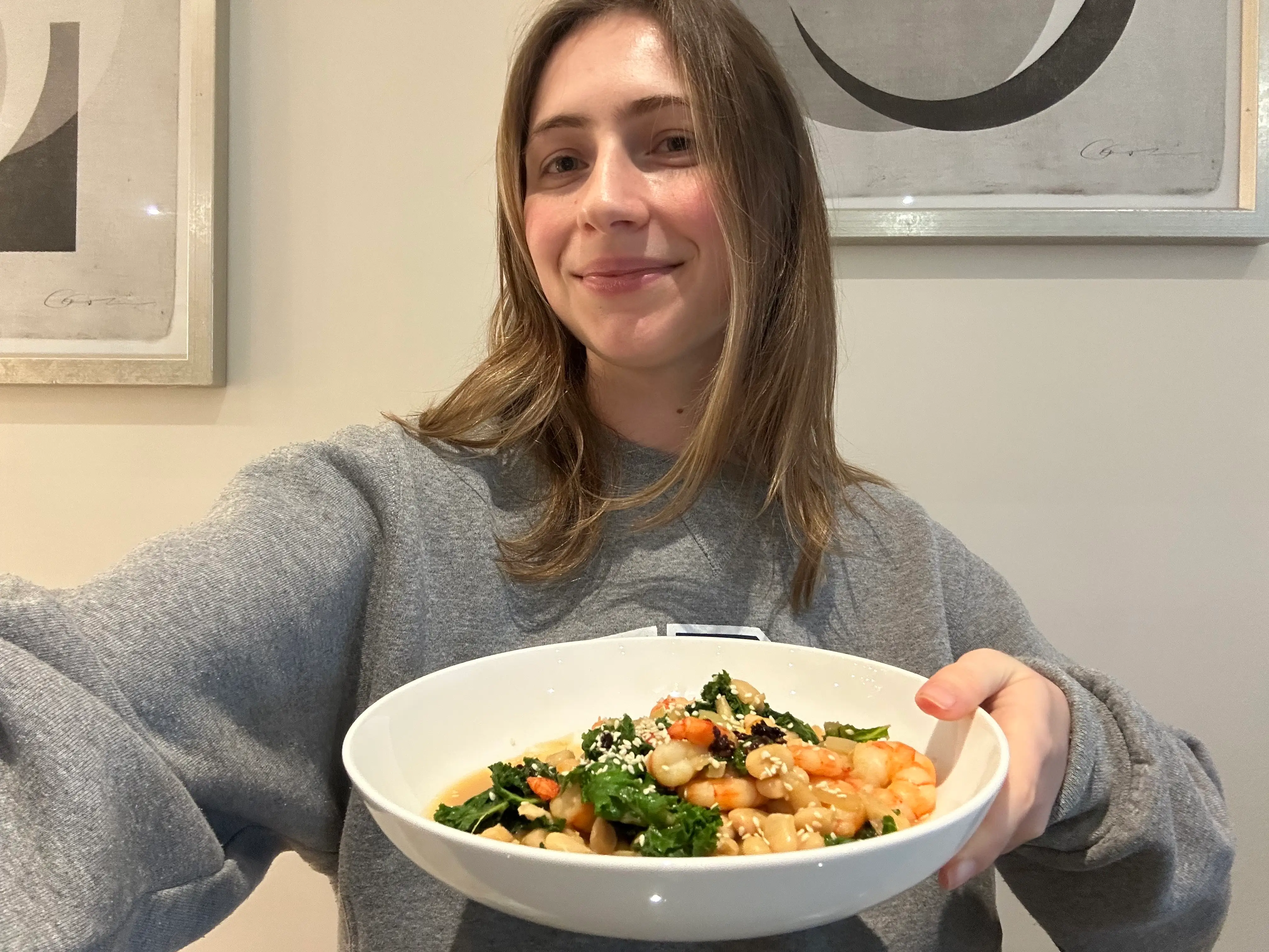 A woman holds a plate of food.