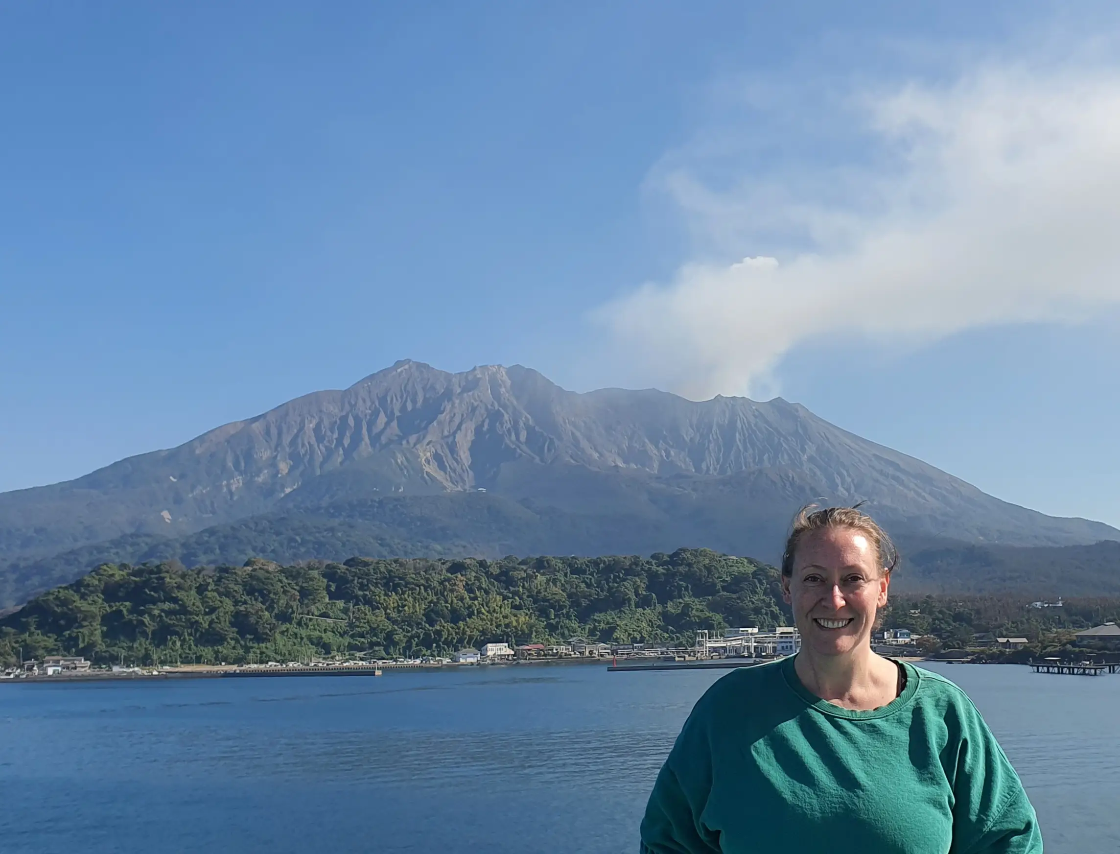 Author Ashley Franzen smiling in front of mountain, water in Japan