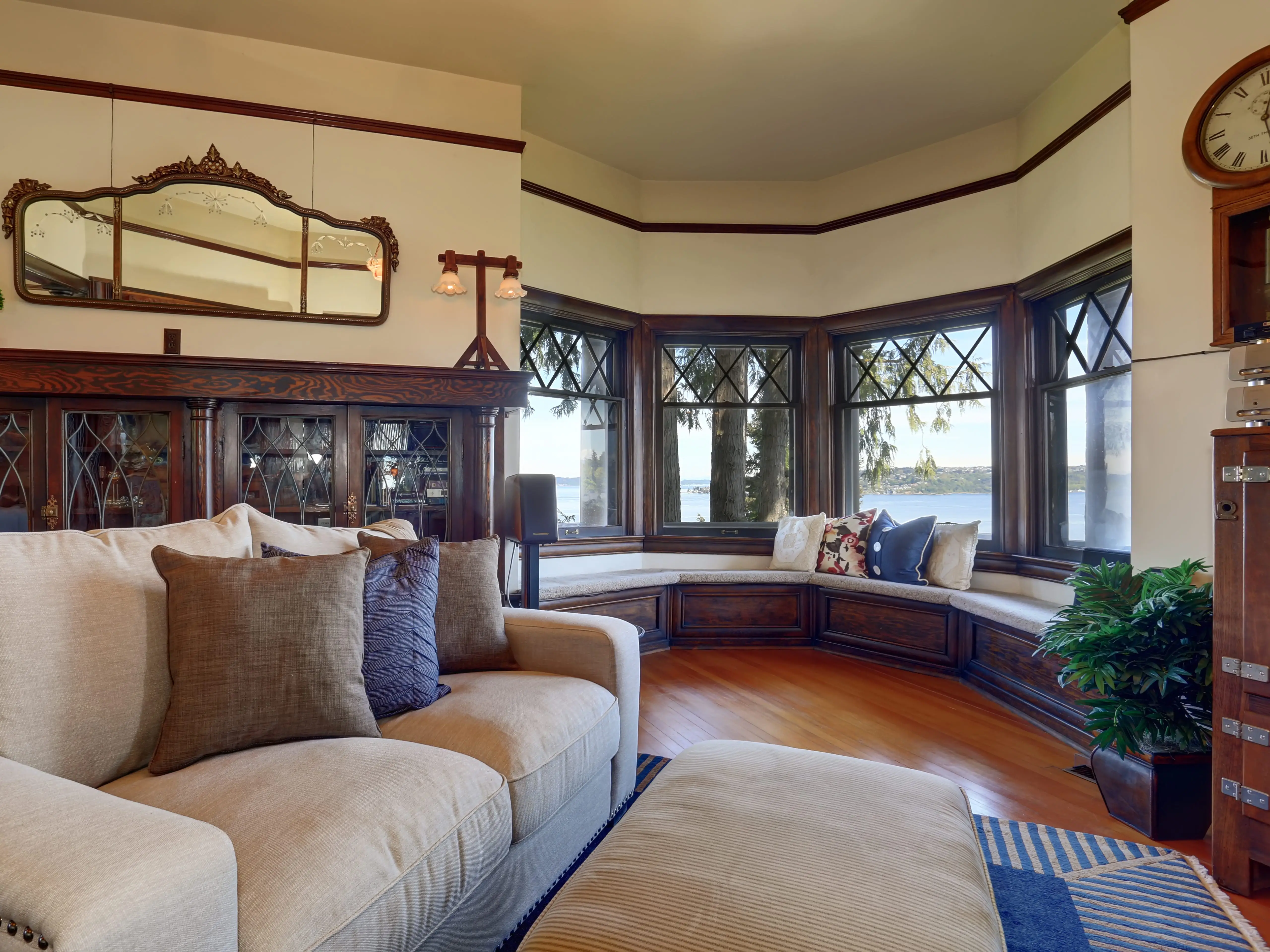 A living room with wood paneling details, a reading nook, and a beige couch.