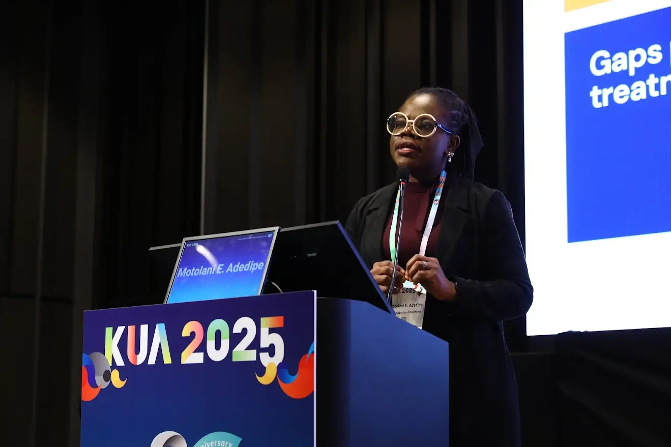 A woman giving a presentation at a podium on stage.