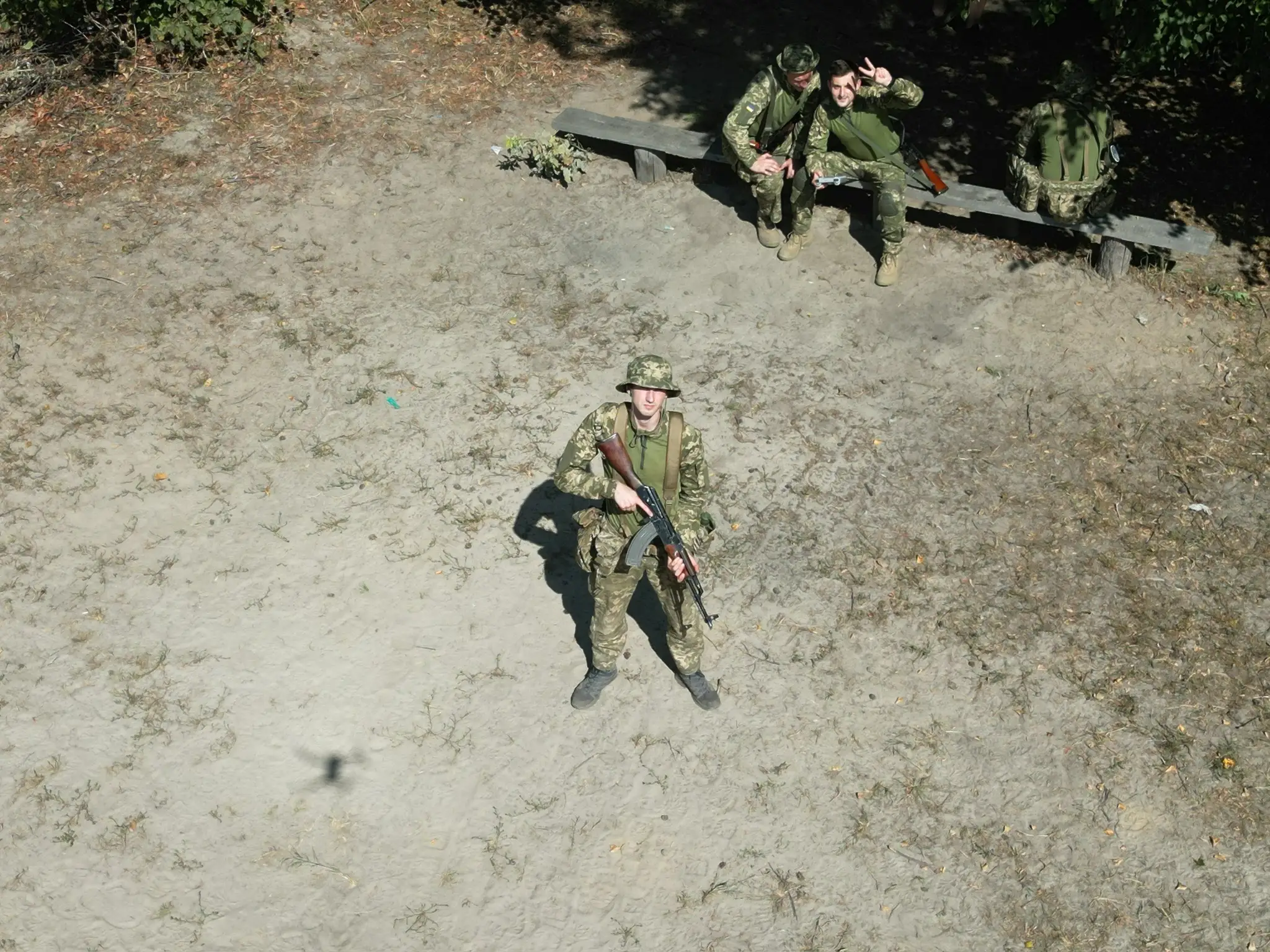 Zhluktenko, with an AK-47, poses for a photo shot from overhead.