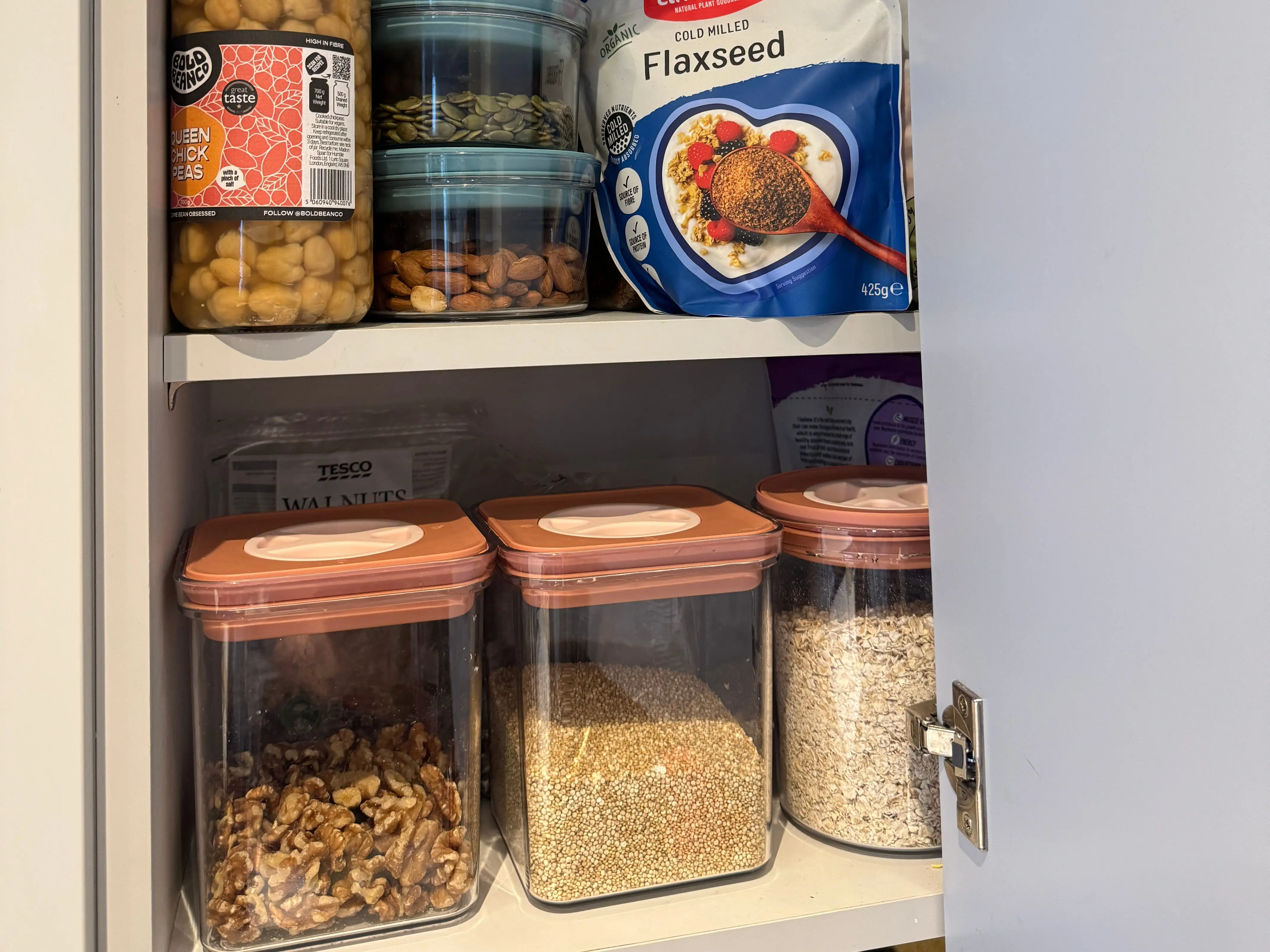 A cupboard with shelves of seeds, beans, nuts, and pulses.