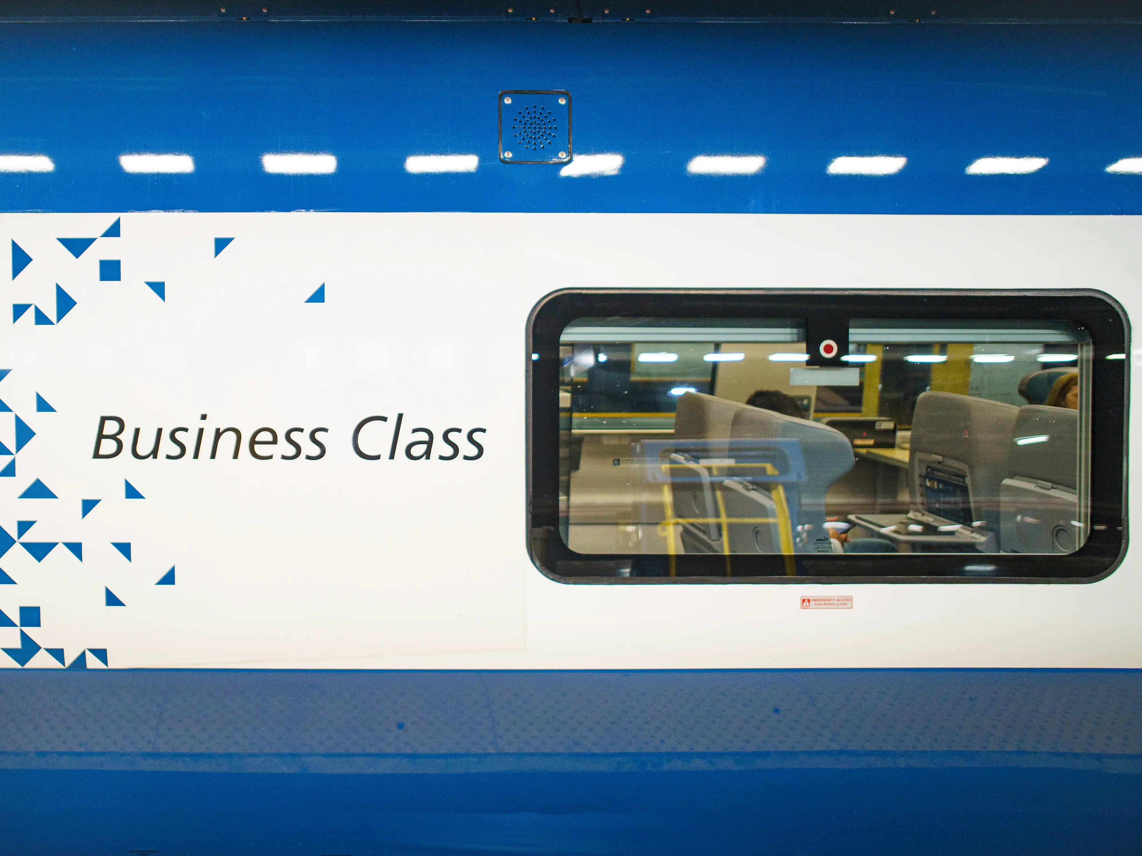 A blue business-class car with a window on the right on an Amtrak NextGen Acela train