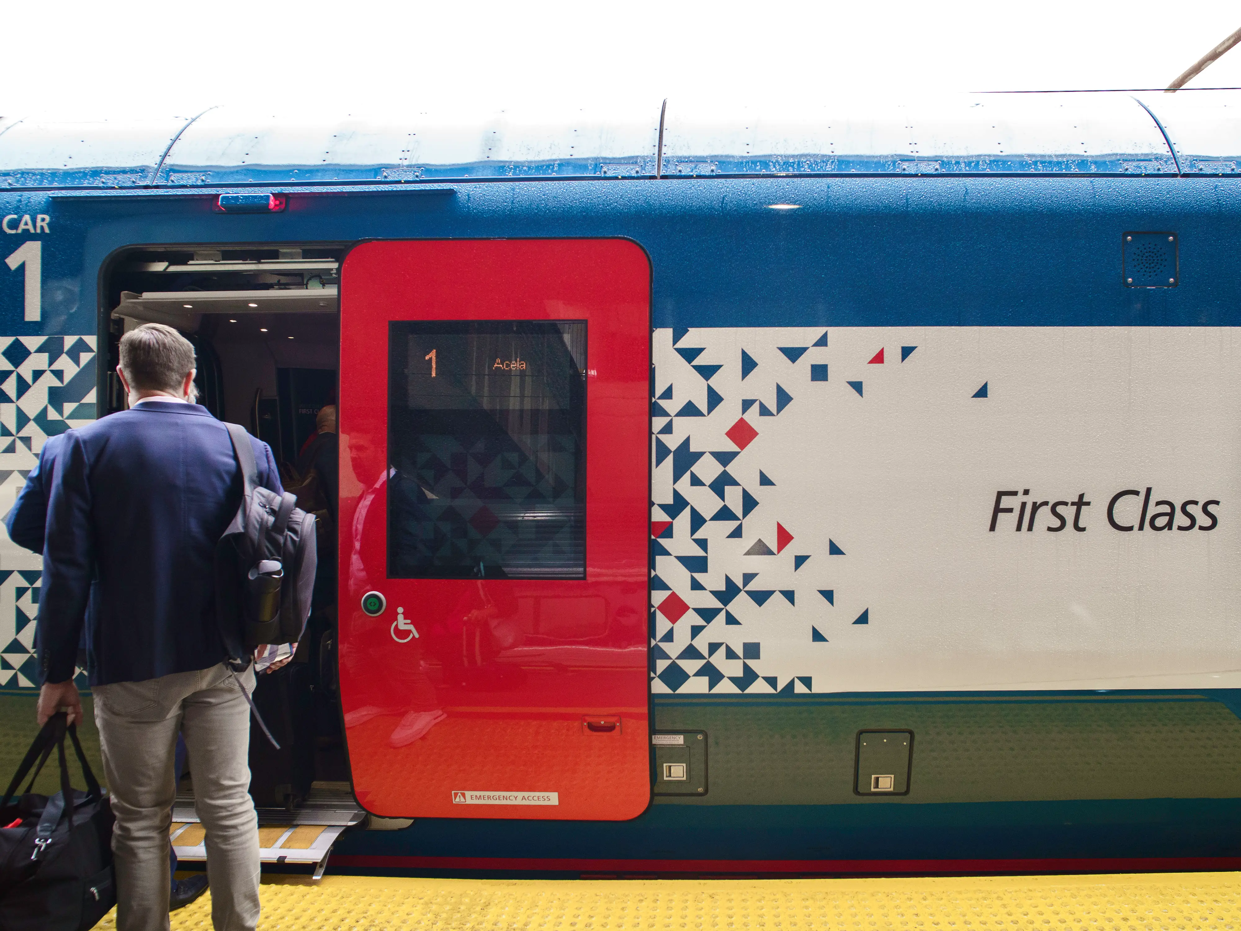 Passengers on the left board a first-class train car on the Amtrak Acela NextGen