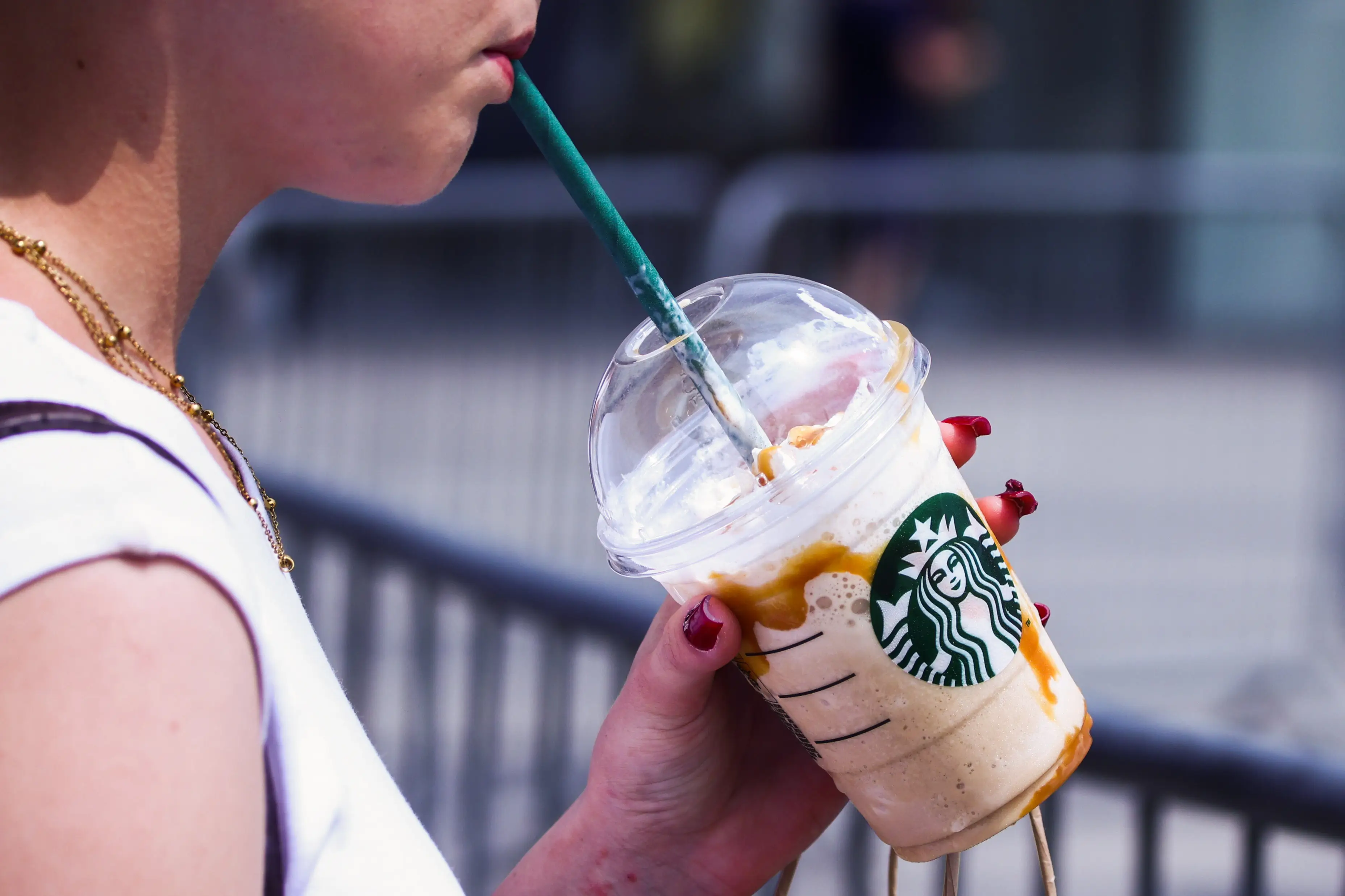 Starbucks cup being sipped by a woman