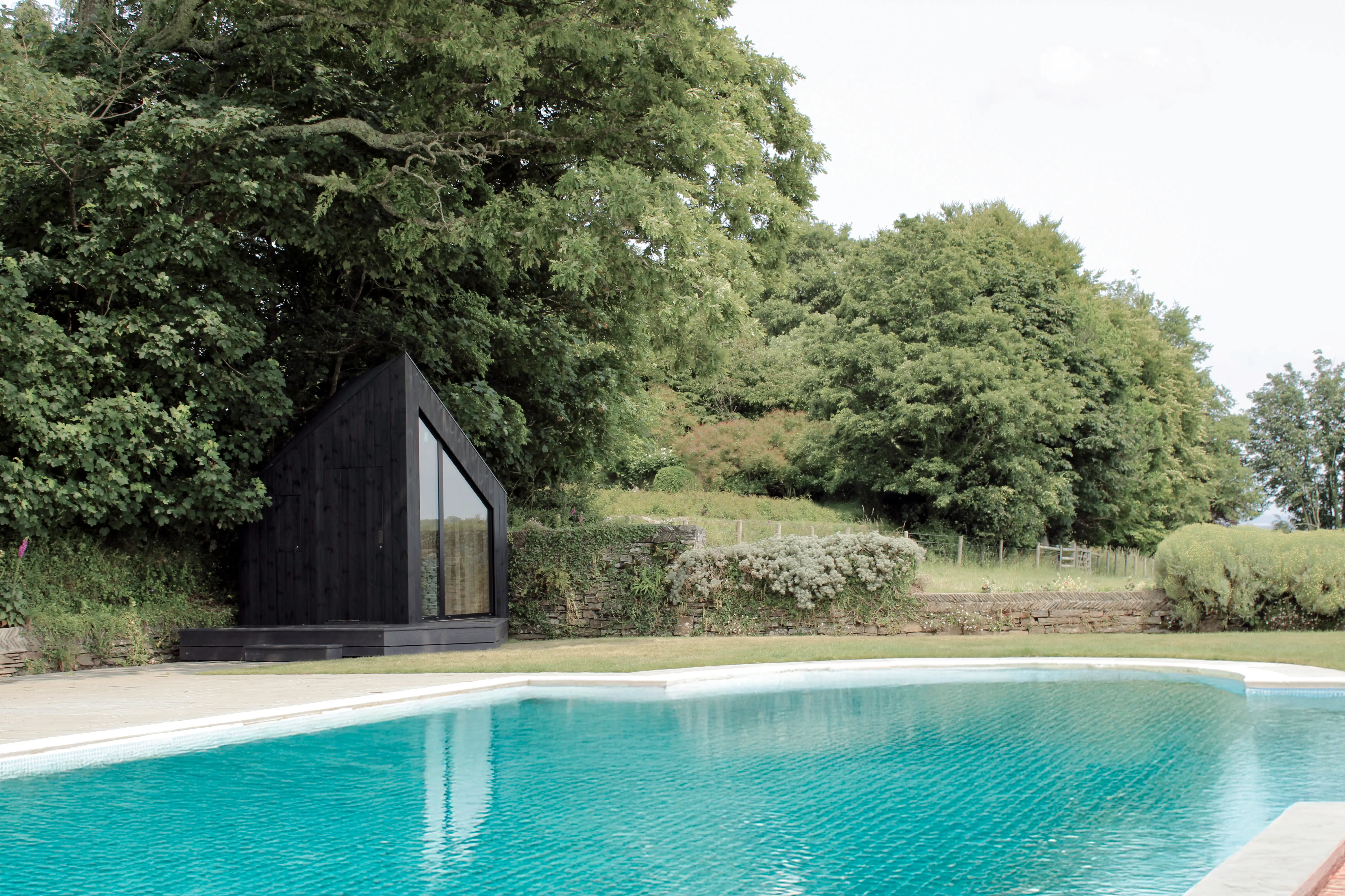 The small-sized Niwa unit sits in a backyard next to a pool.