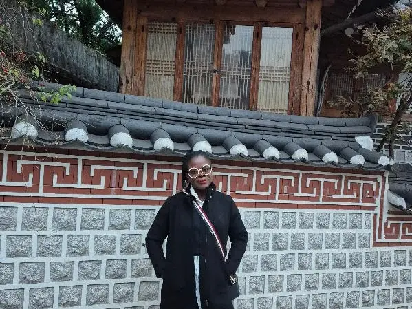A woman posing in Bukchon Hanok Village in South Korea.