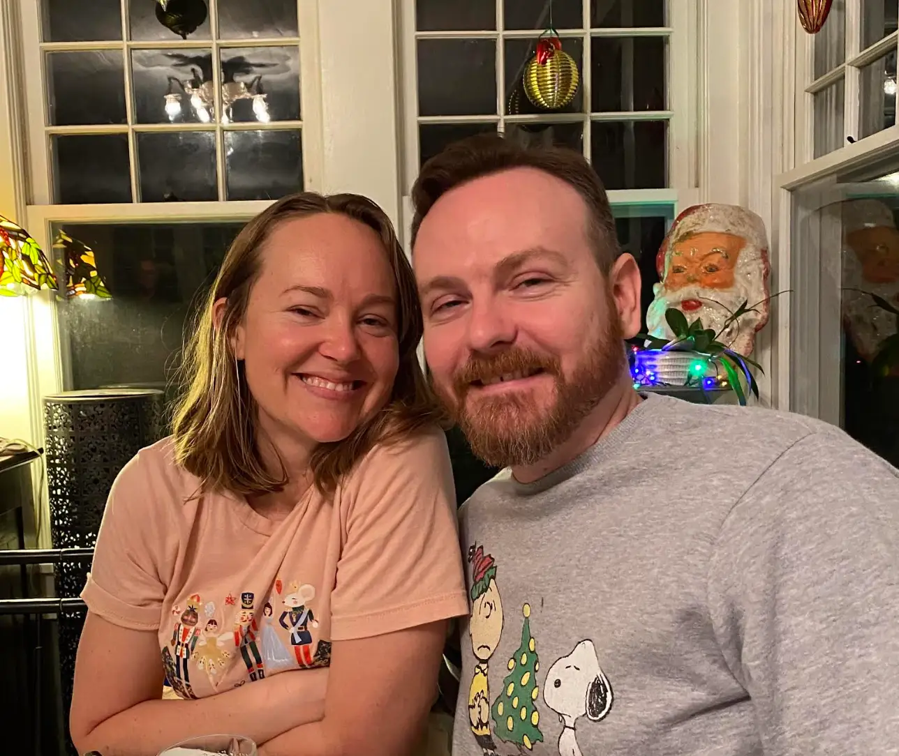 The writer and her husband sitting side by side amid Christmas decor.