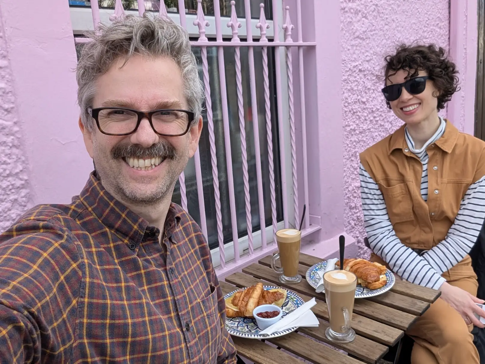 The writer and her husband eating breakfast sandwiches and drinking coffee outside in Ireland.
