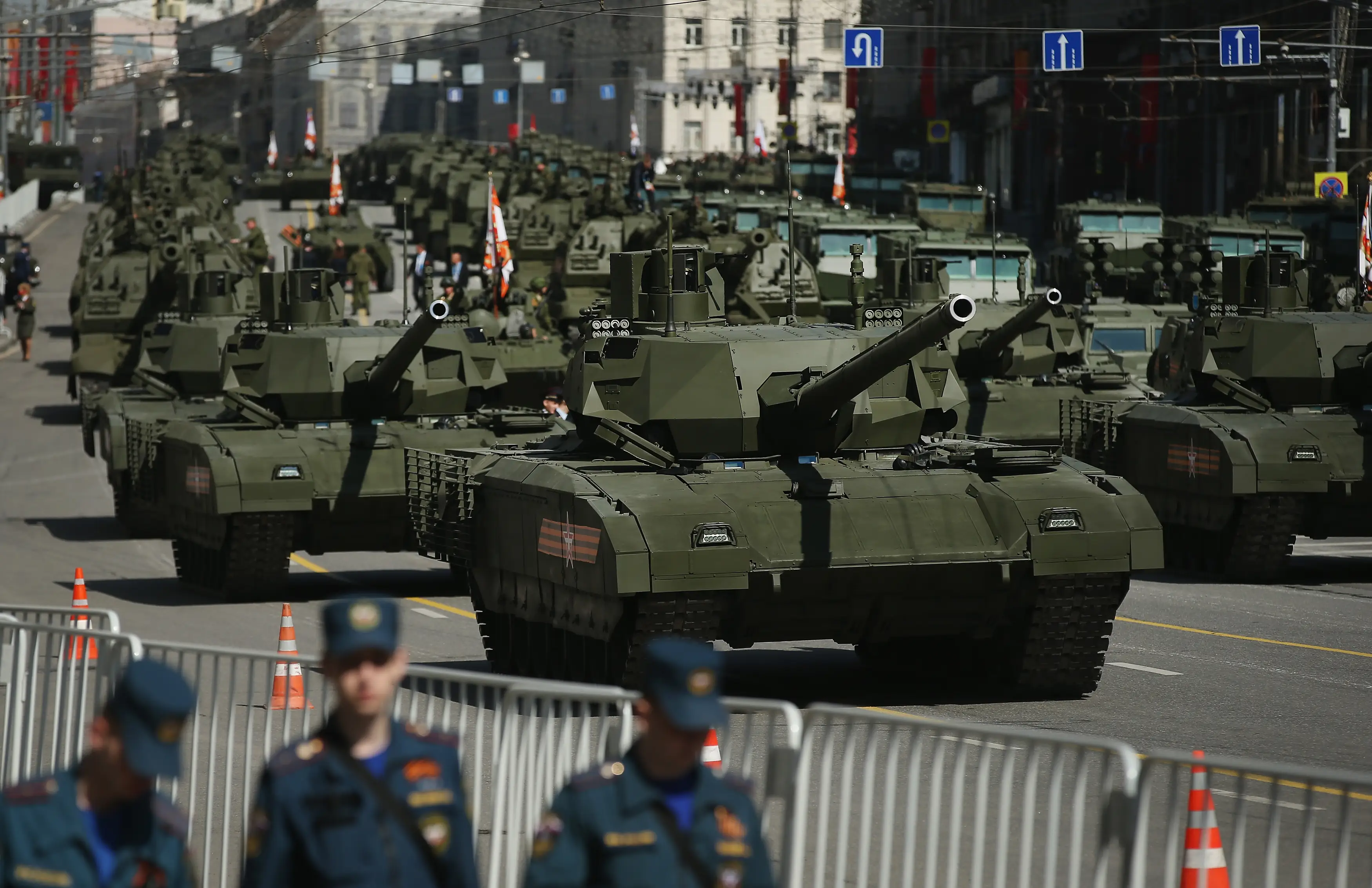 A column of green tanks on a city street