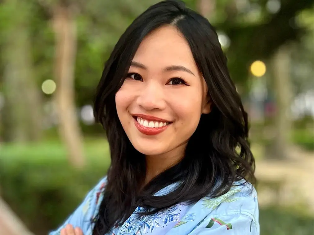 Victoria Zuo smiles for a photo with arms folded across her chest.