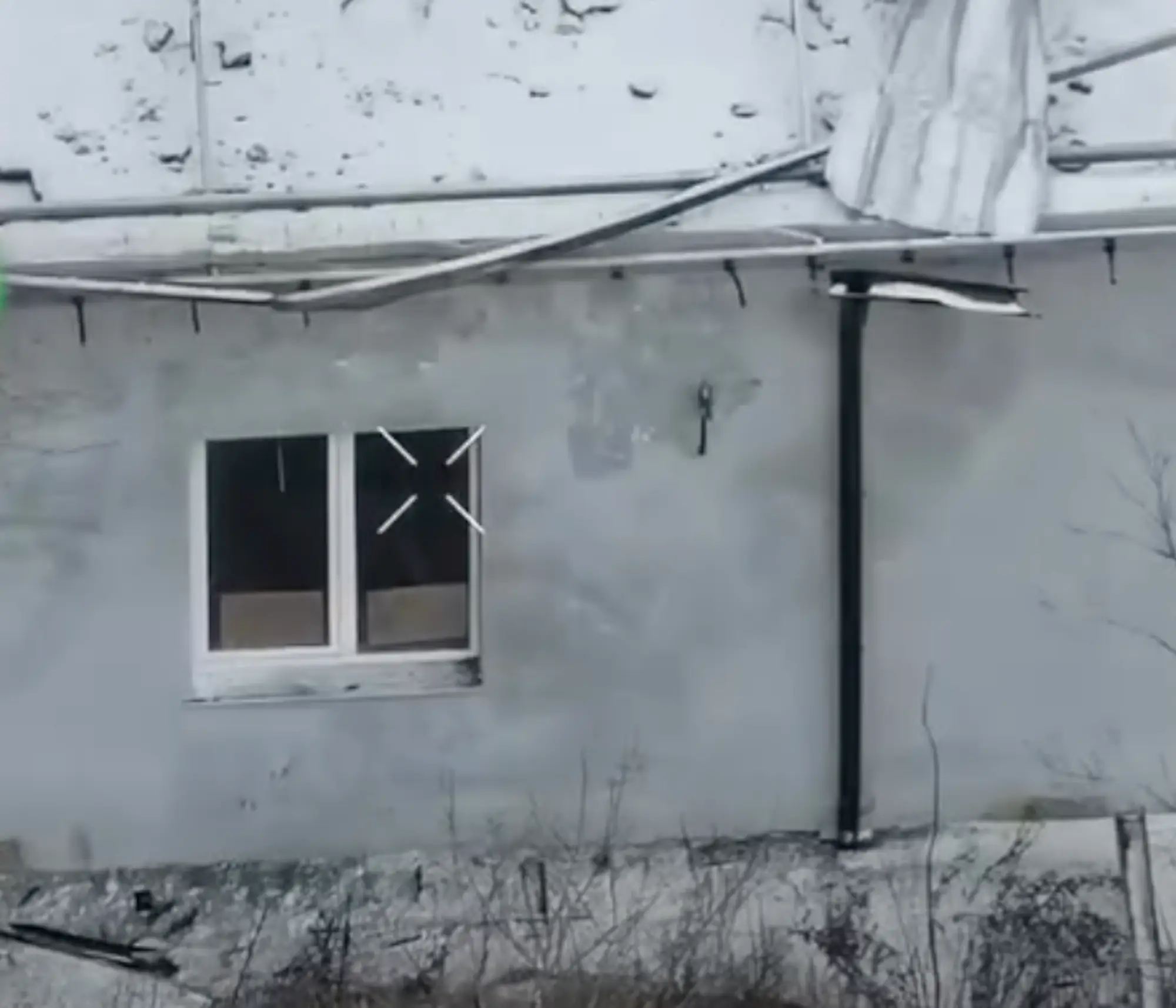 A pale building with two pieces of cardboard in the window