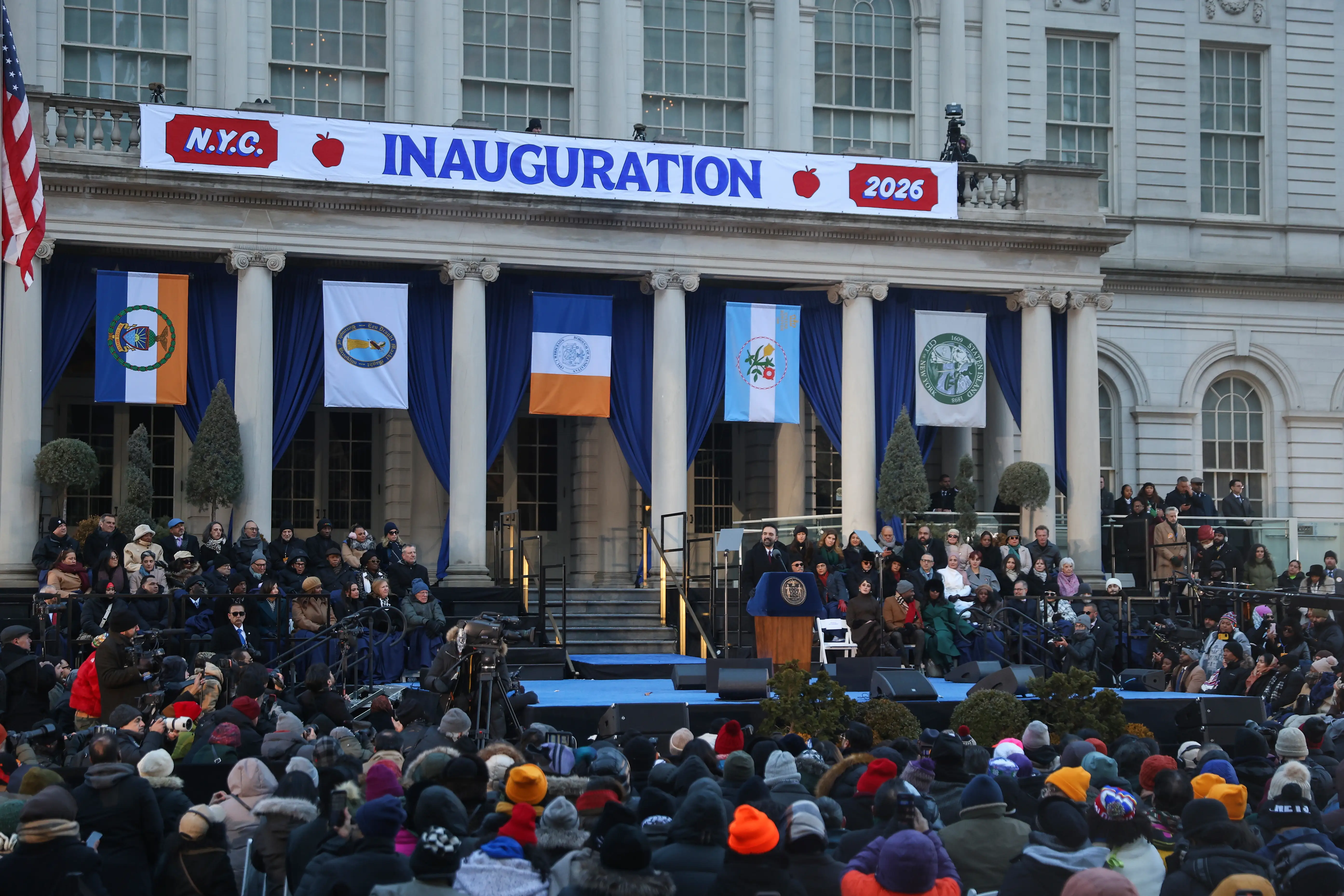 NYC City Hall with Zohran Mamdani on stage as new mayor
