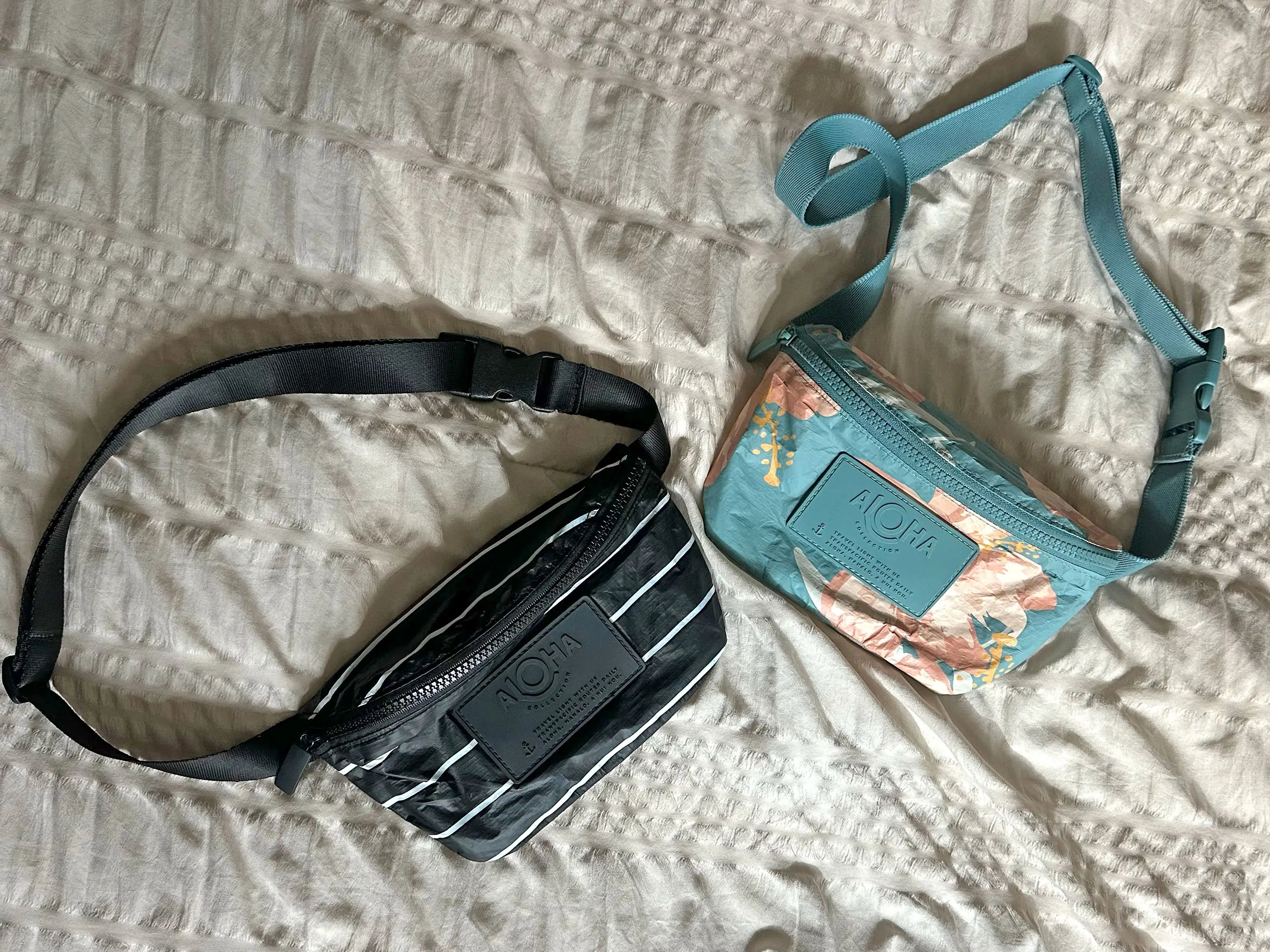 Two belt bags on a bed.