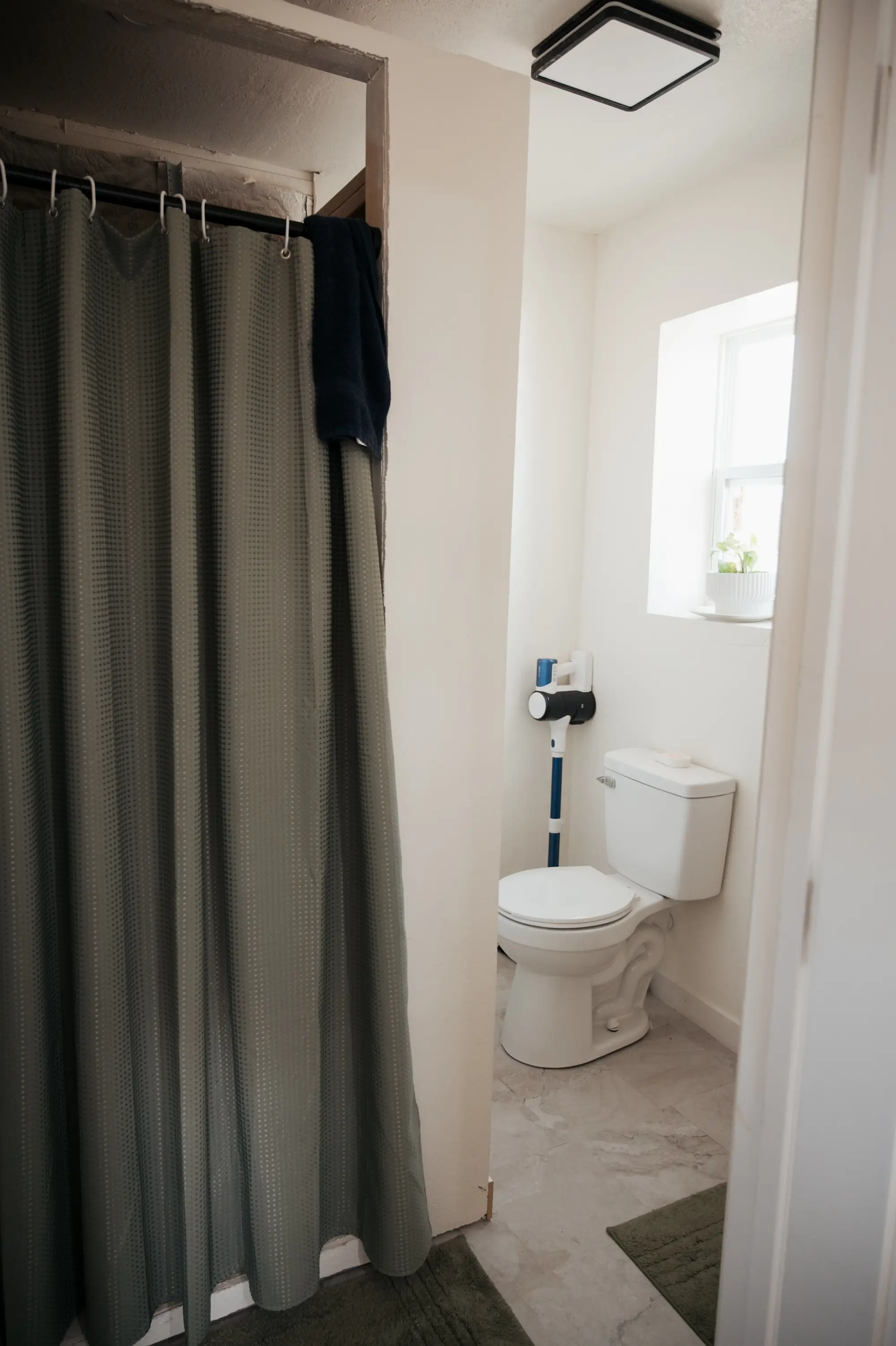 A bathroom with a shower and a toilet in the corner.