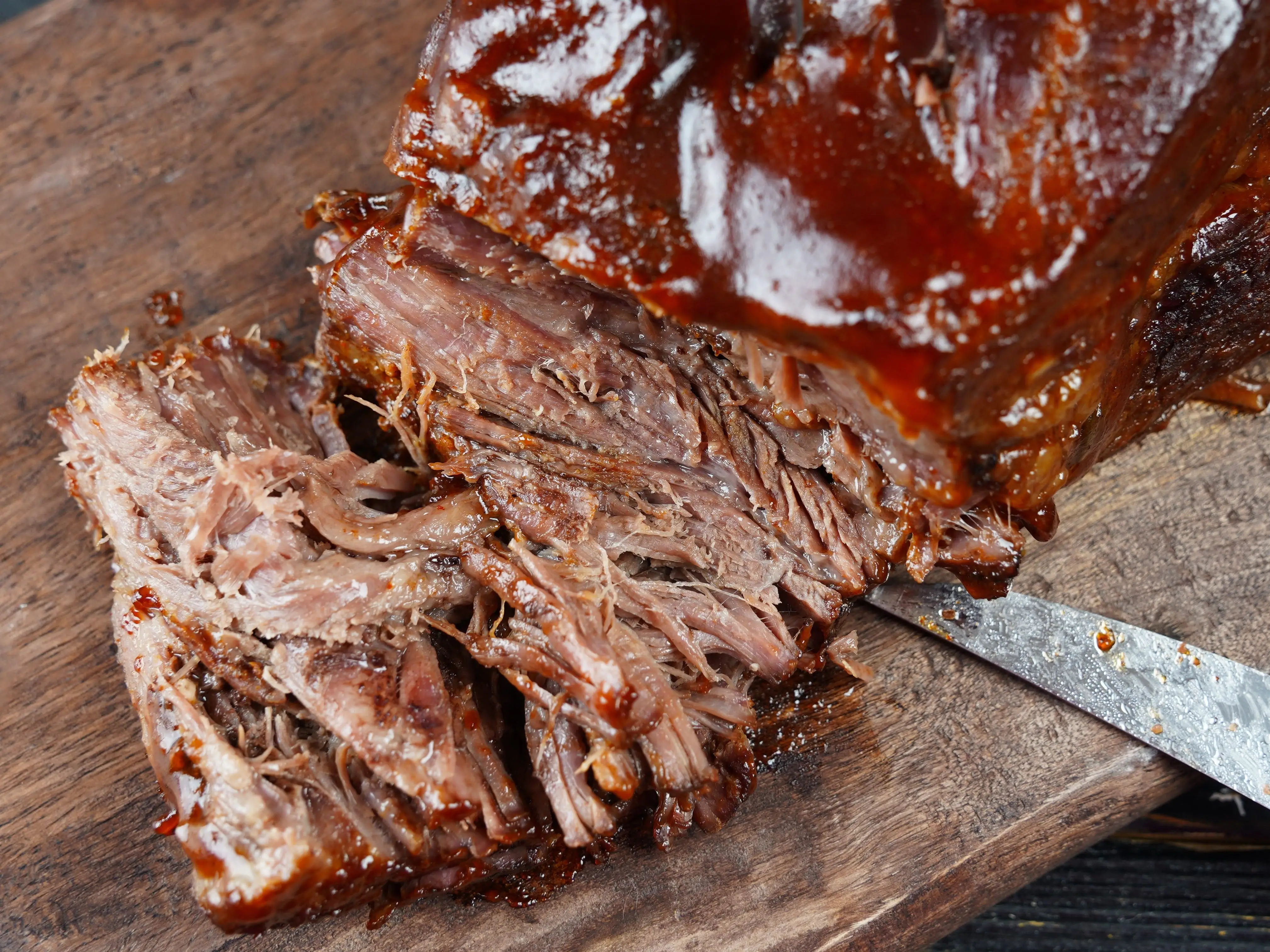 pulled beef brisket on a beef cutting board