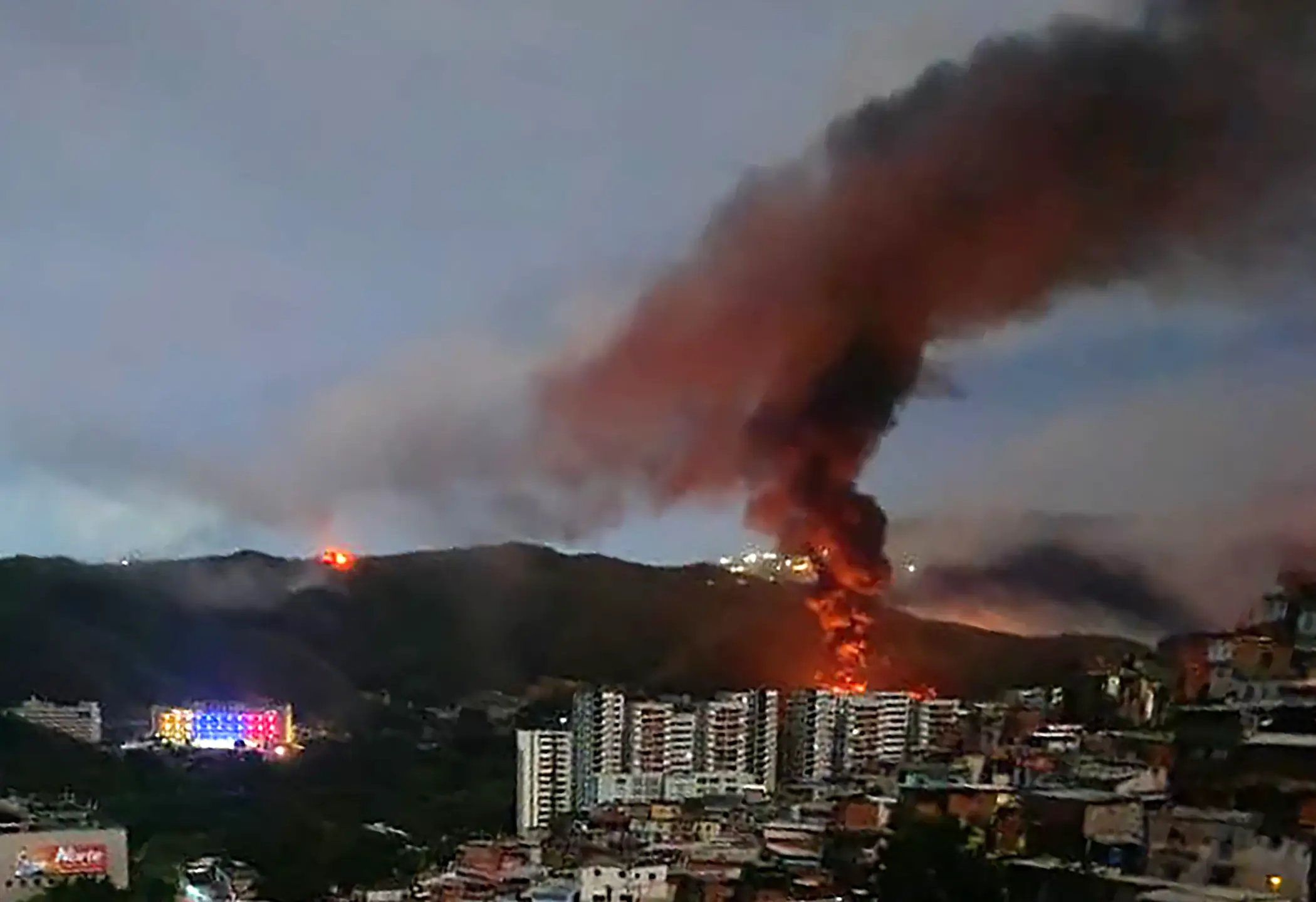 Fire at Fuerte Tiuna, Venezuela's largest military complex, is seen from a distance after a series of explosions were heard in Caracas on January 3, 2026.
