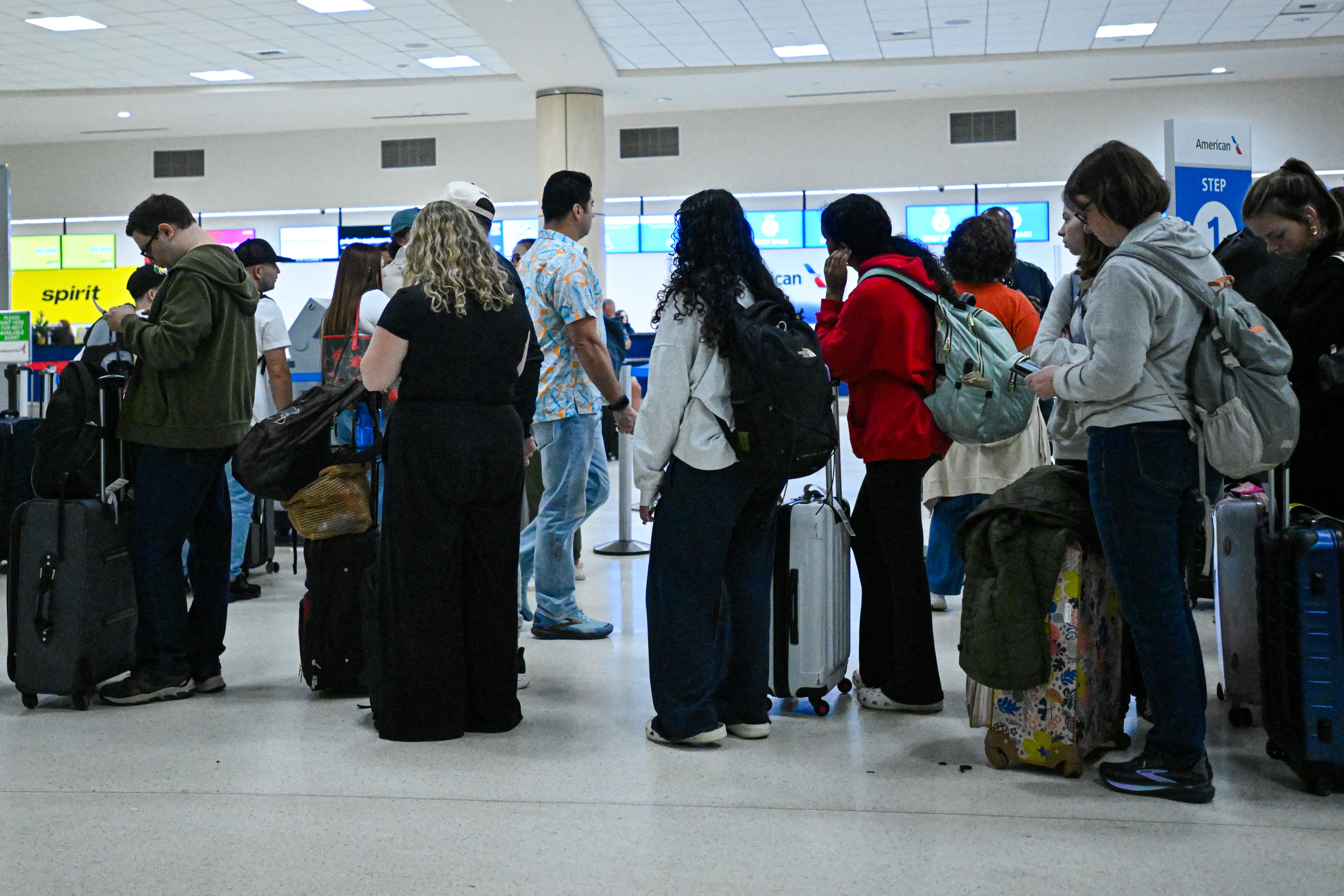 Passengers wait at Luis Munoz Marin International Airport as all flights are cancelled following US military action in Venezuela