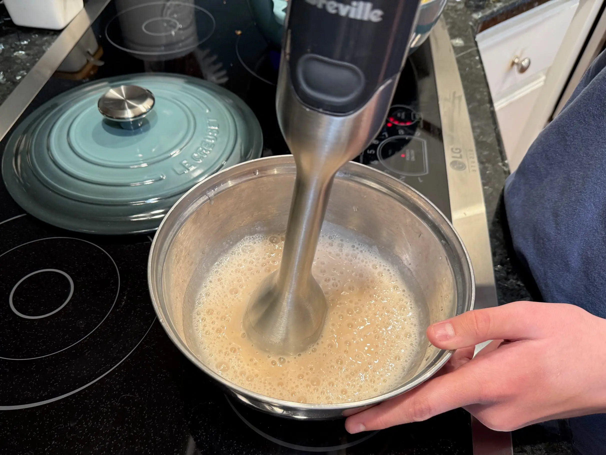 Kristina uses an immersion blender to puree cannellini beans and liquid.