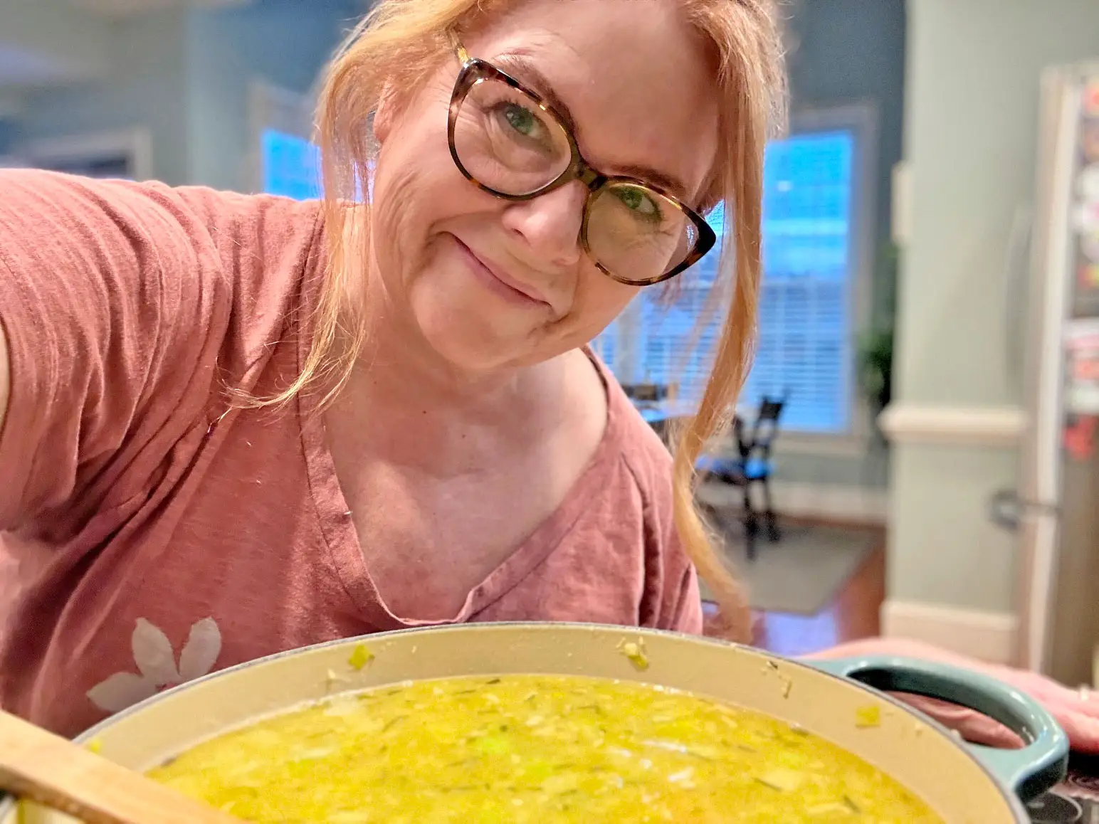 Kristina takes a selfie with a large pot of soup.