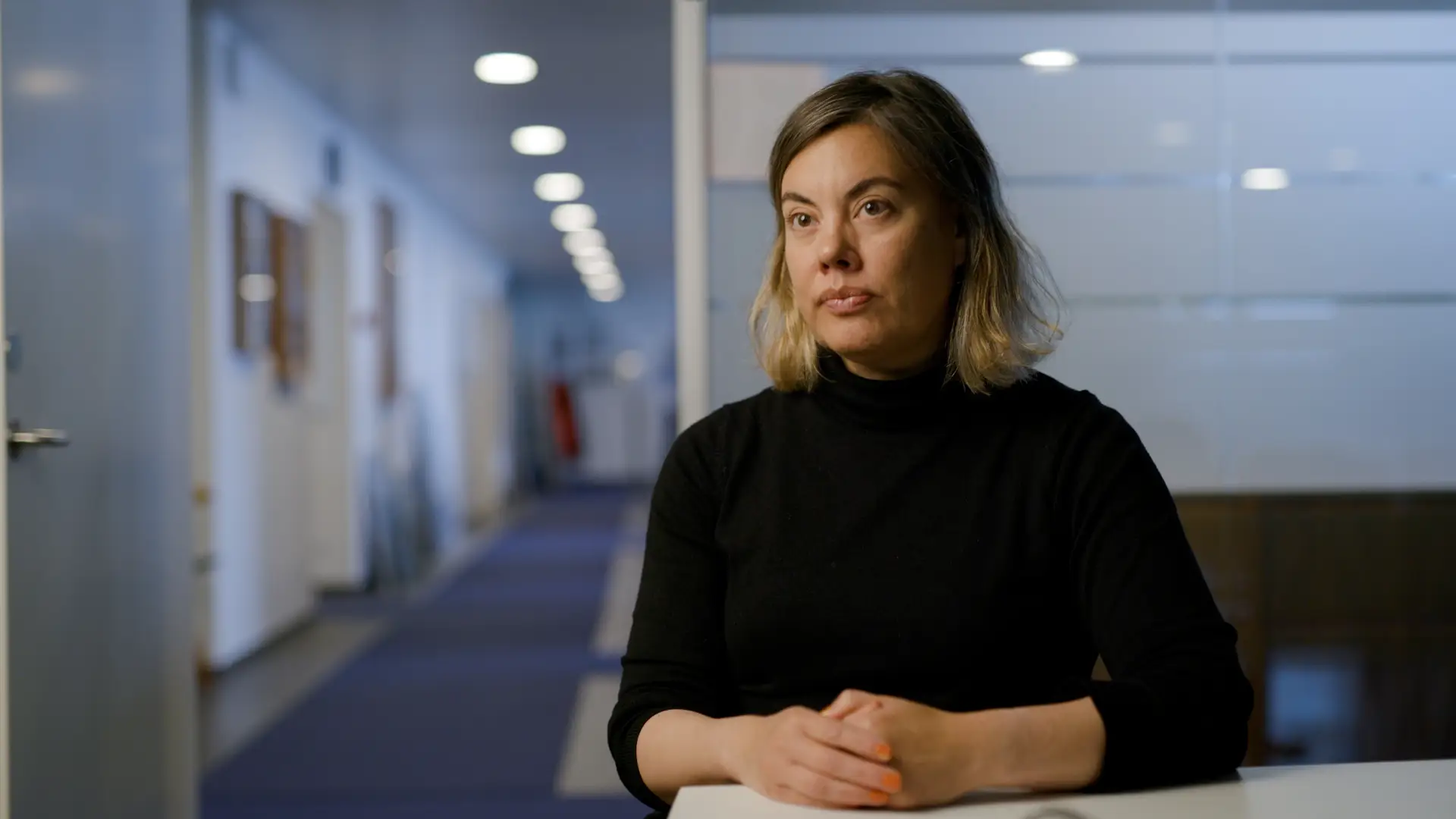Naaja Nathanielsen in black shirt in office setting.