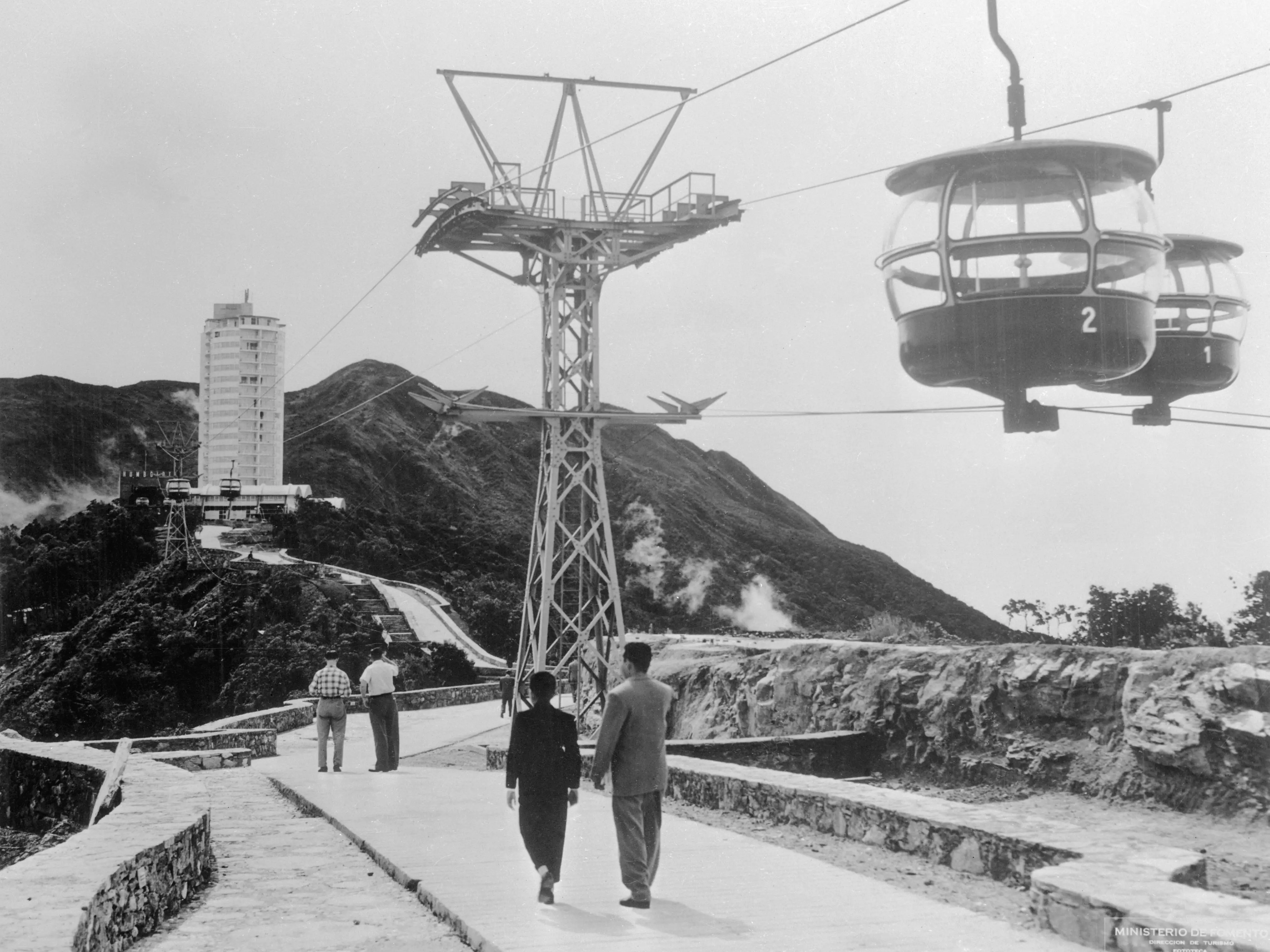 The capital of Venezuela, Caracas, is shown in a 1963 panoramic view. In the center are the twin towers of the Simon Bolivar Center. Here the cable car leading to Humboldt Hotel on the peak of Mt. Avila, Caracas.
