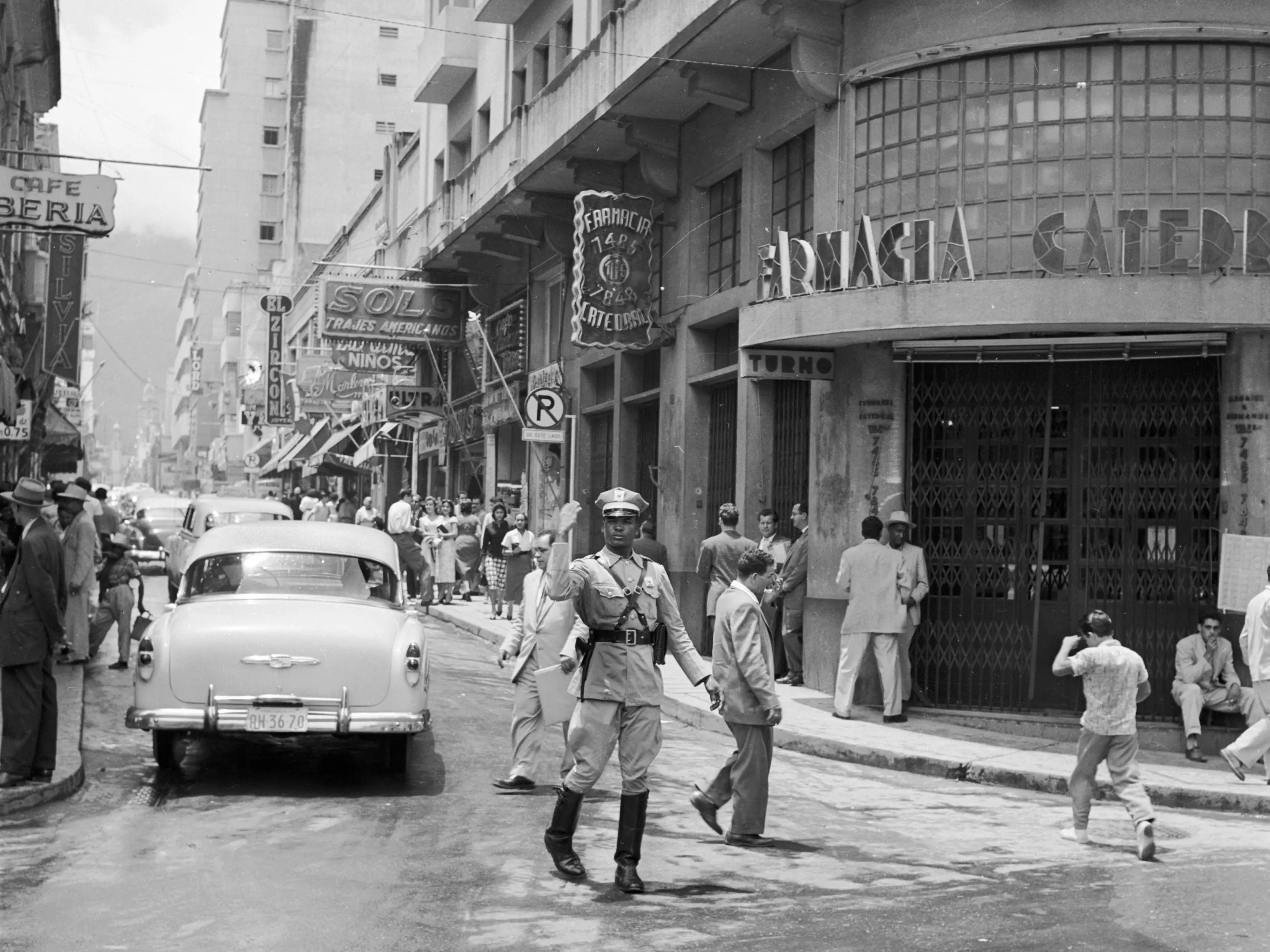 circa 1955: A policeman directing traffic around a busy corner of central Caracas, Venezuela.