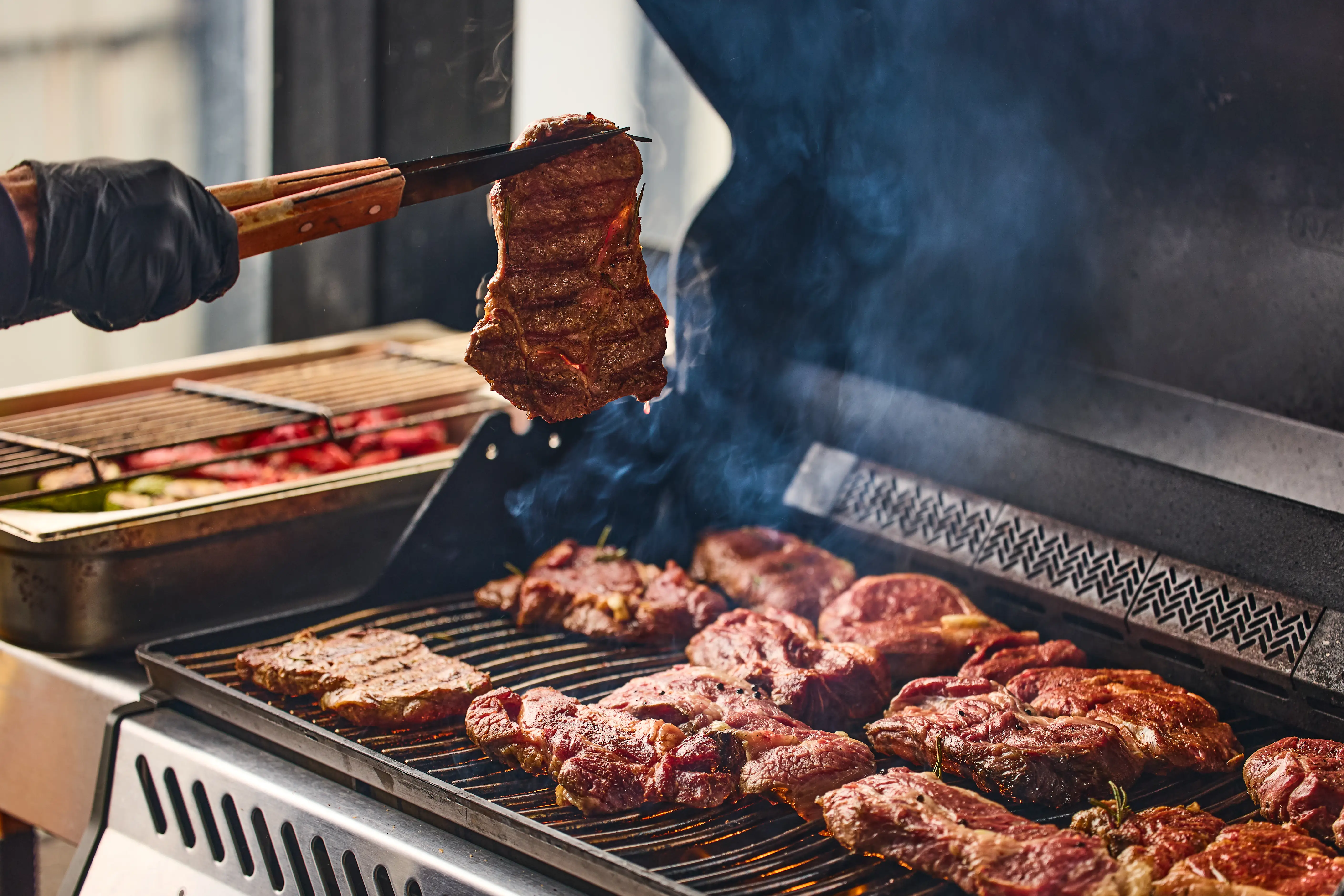 piles of beef steak on a grill