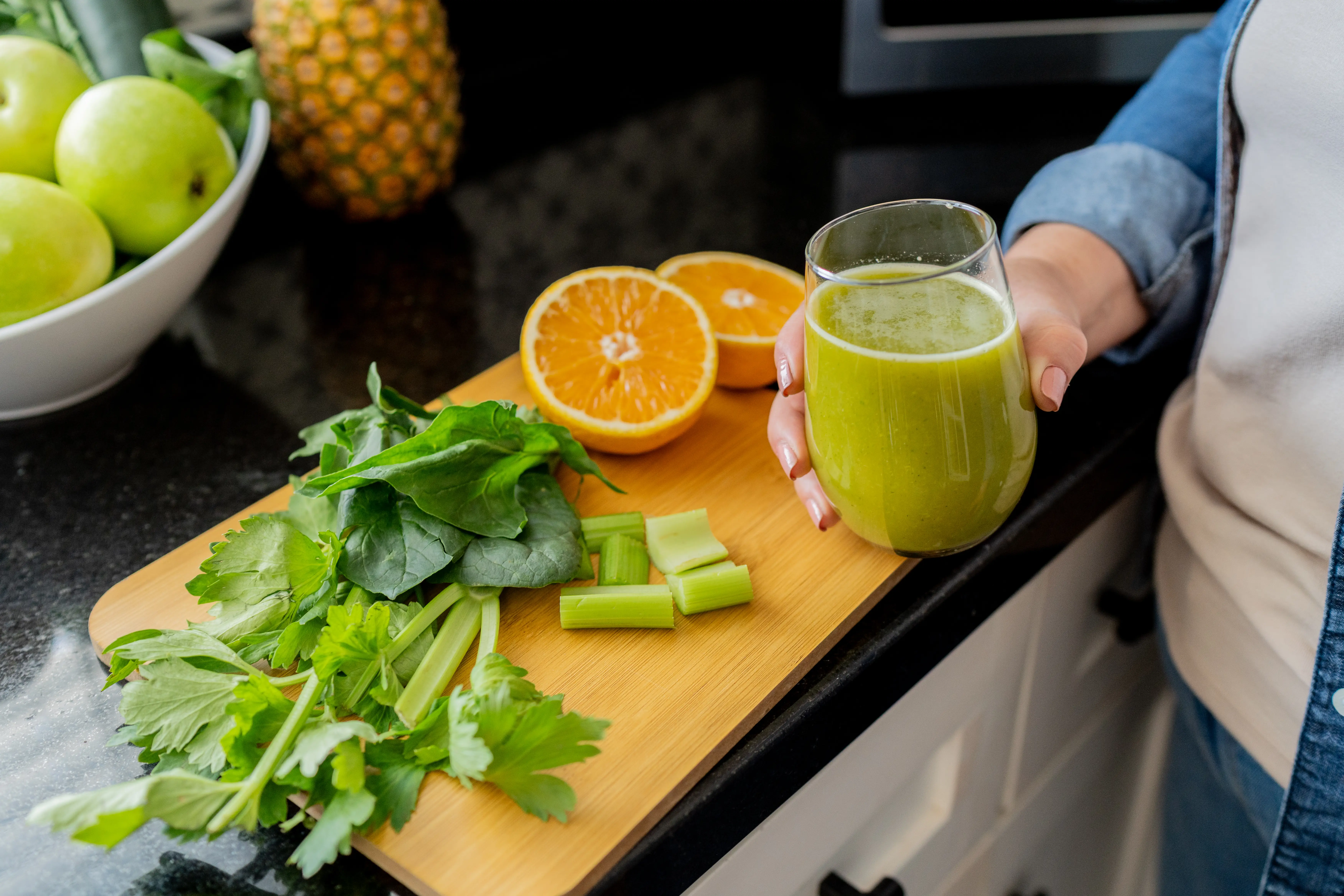 a close up of a glass of juice from celery, spinach and oranges