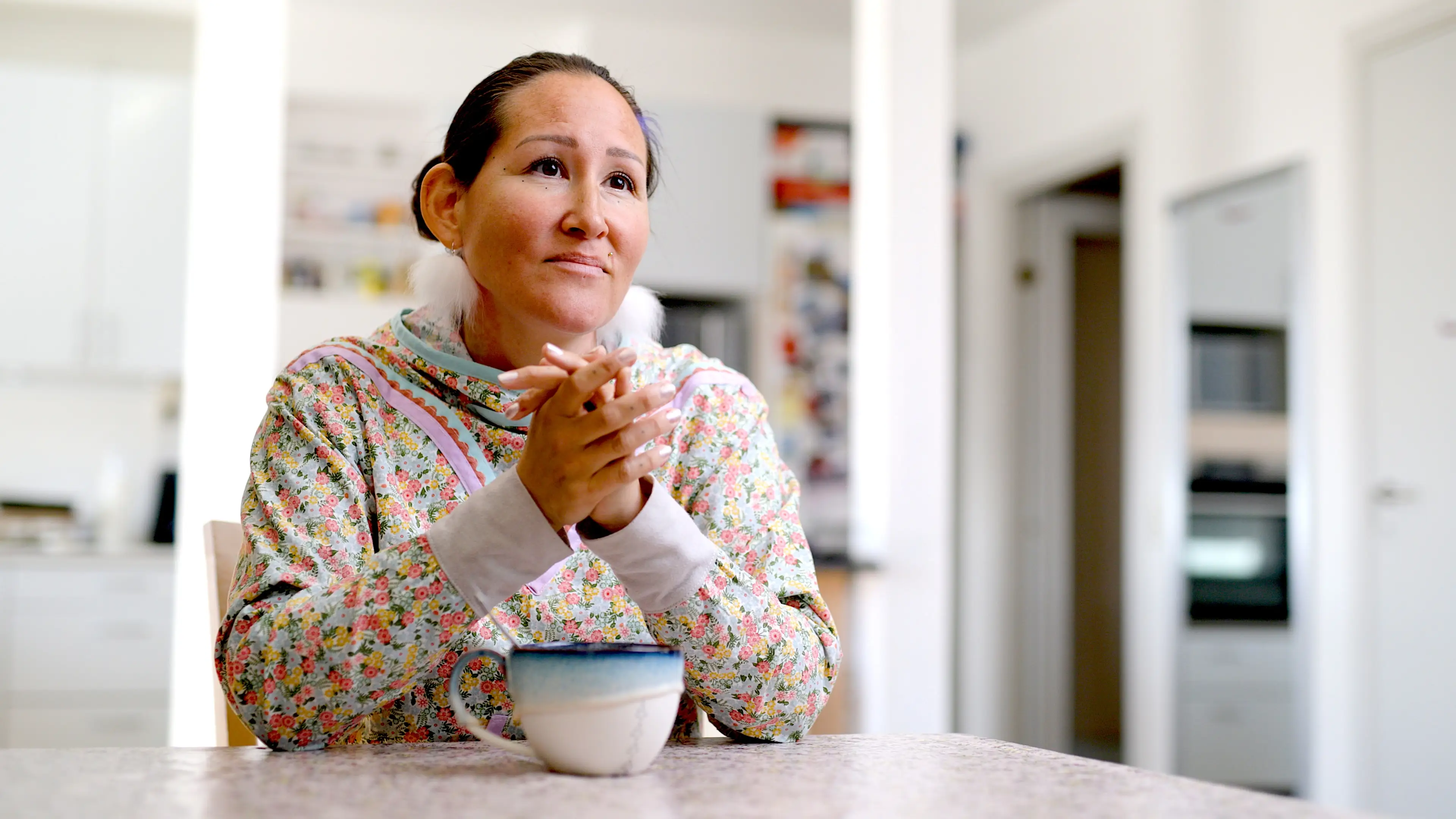 Qupanuk Olsen sitting at table.