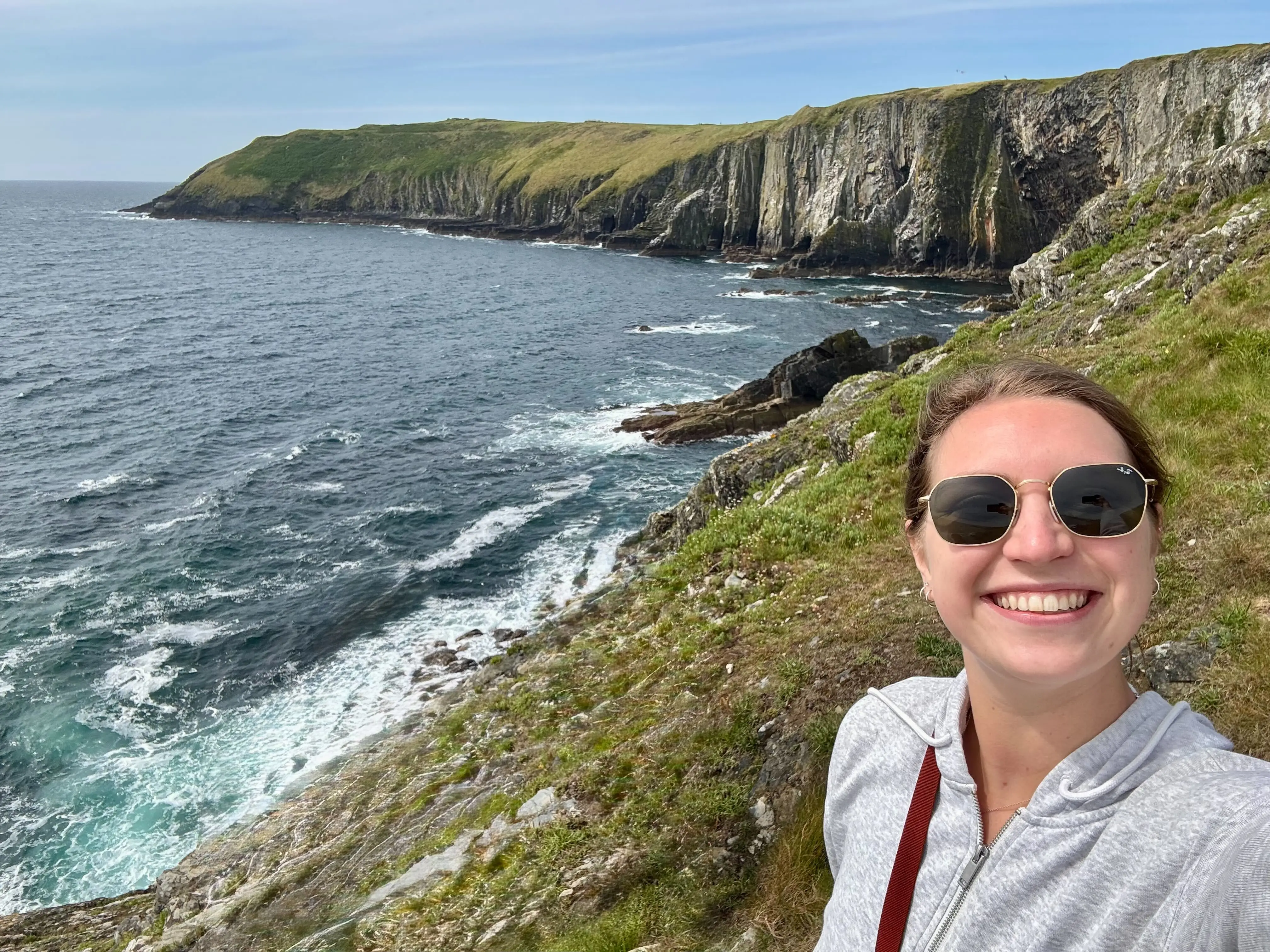 Hannah poses next to cliffs in Ireland.