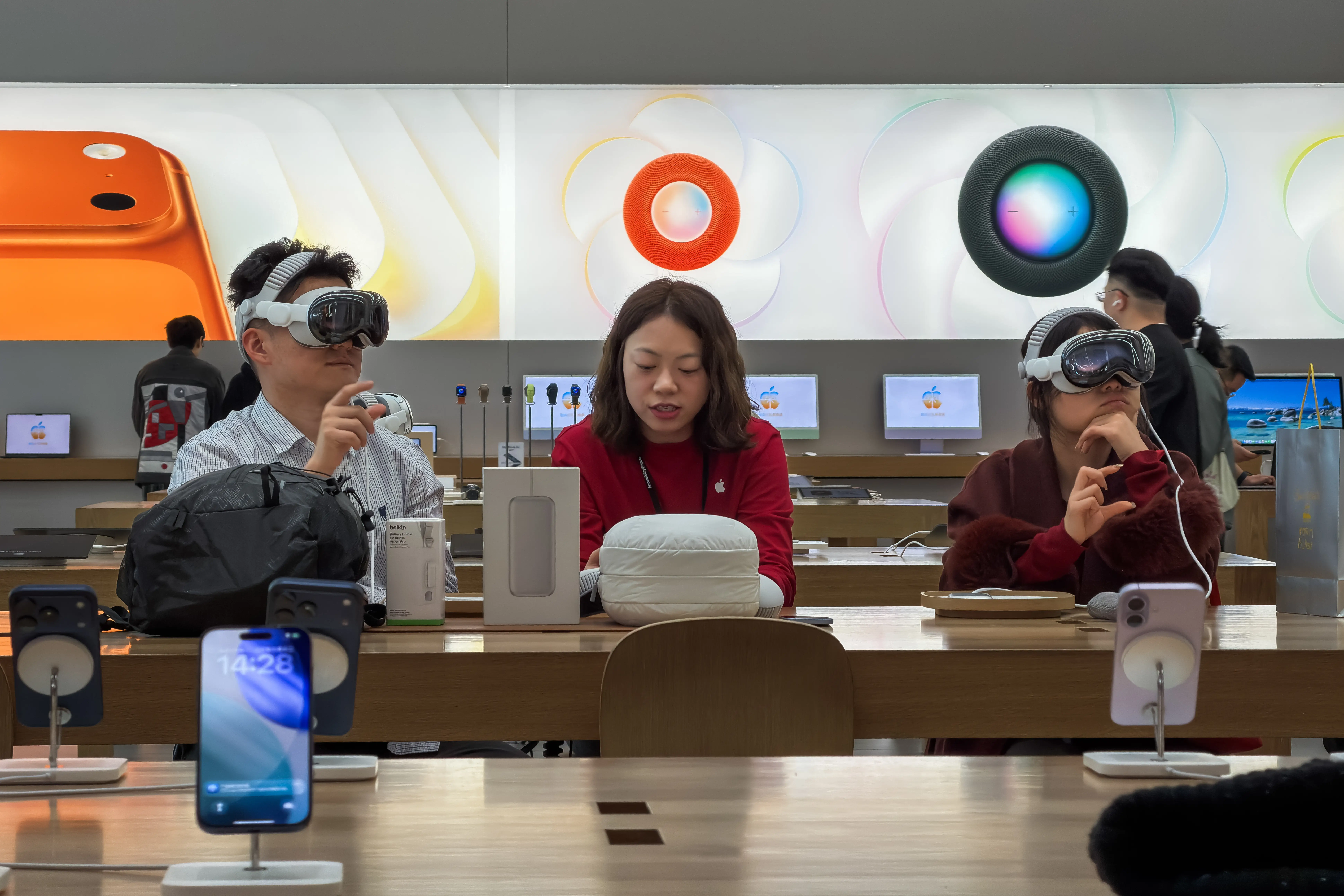 People in an Apple Store try on Apple Vision Pro headsets.