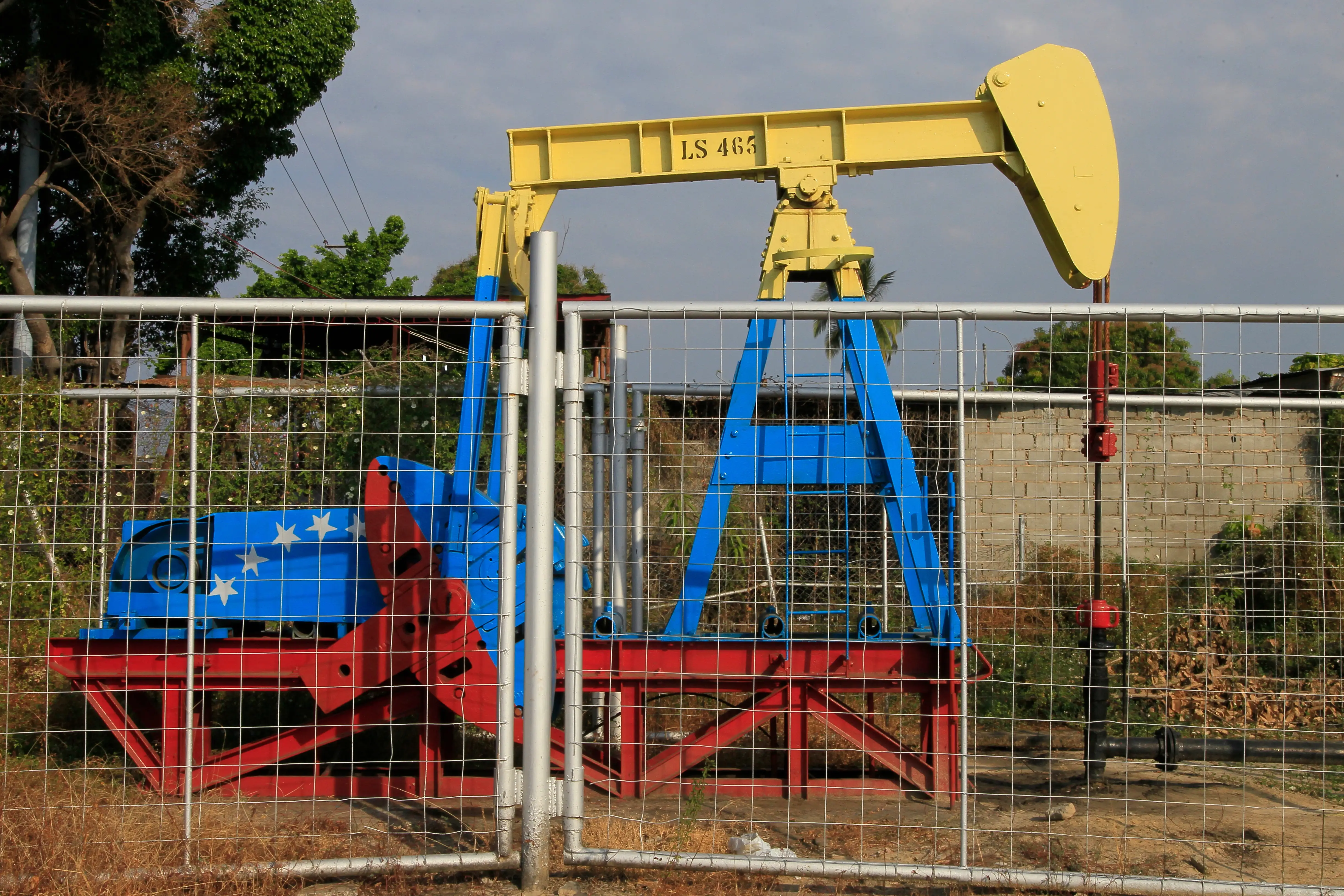 Oil pump jack with de color of the Venezuelan flag is seen and oil field in Cabimas, Venezuela.