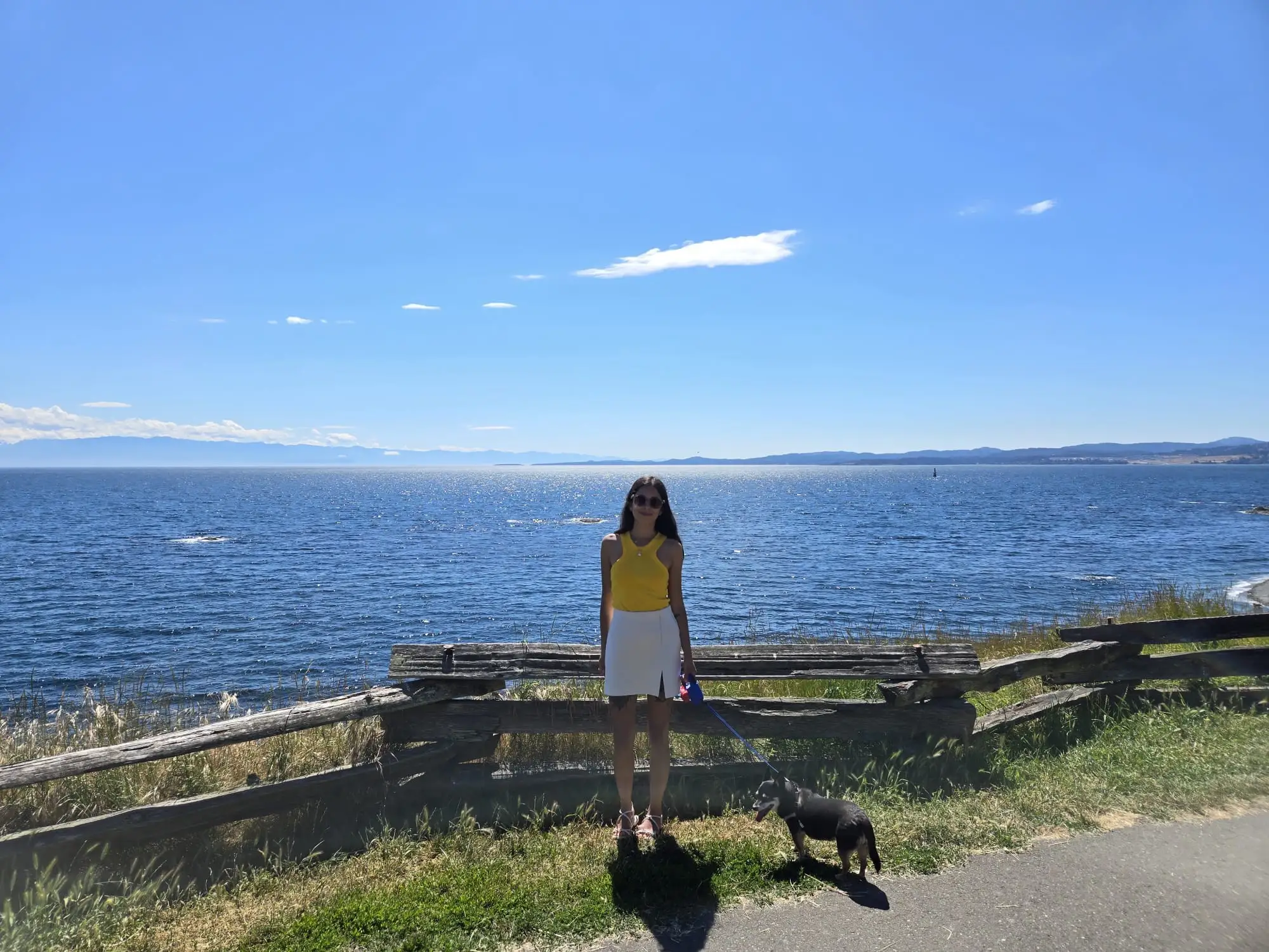 Woman with dog on leash standing in front of water