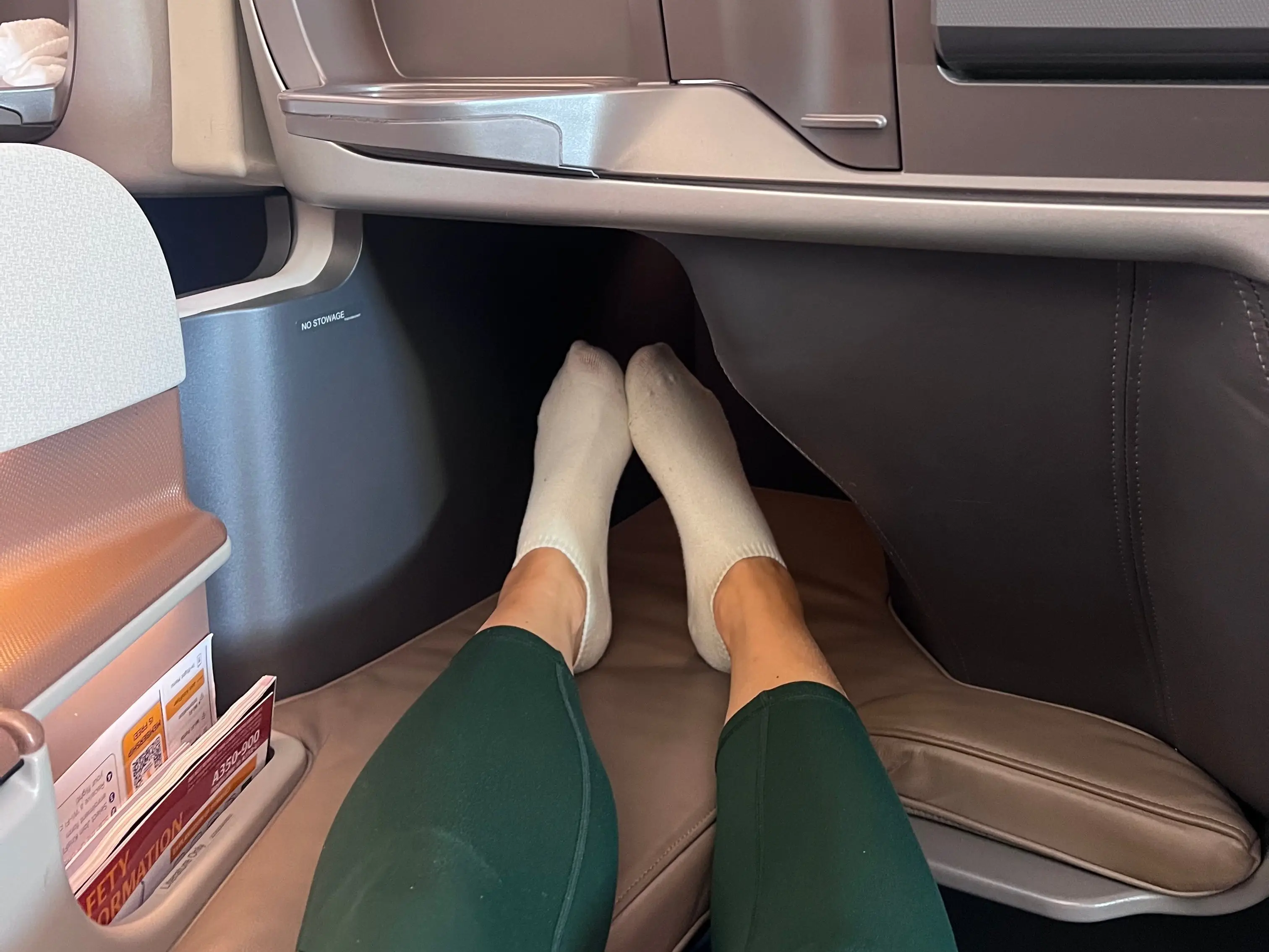 Feet tucked into corner of business class lie-flat seat on Singapore airlines
