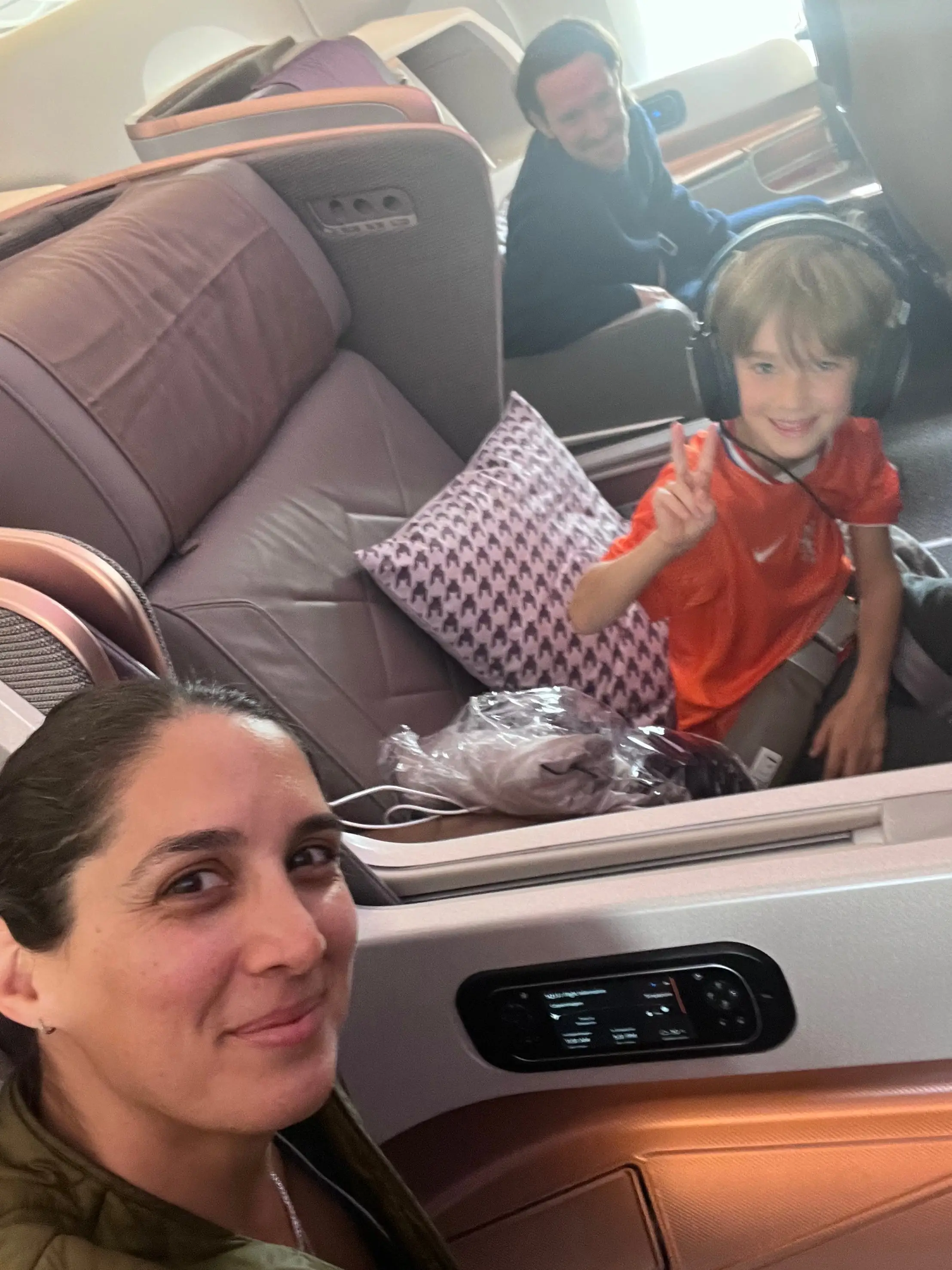 Author and her son smiling in Business class seats on Singapore airlines