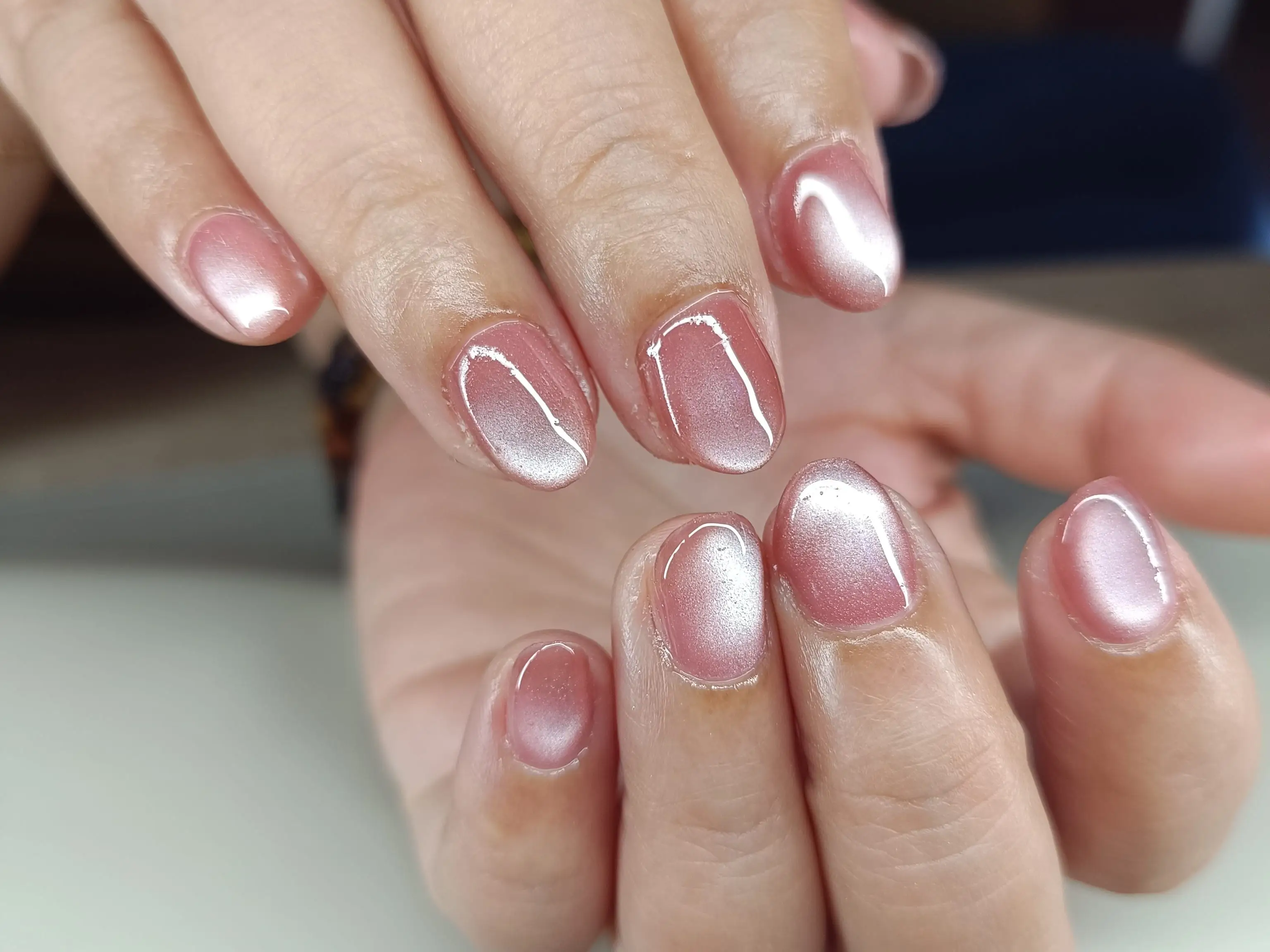 A cool-toned pink cat-eye manicure.